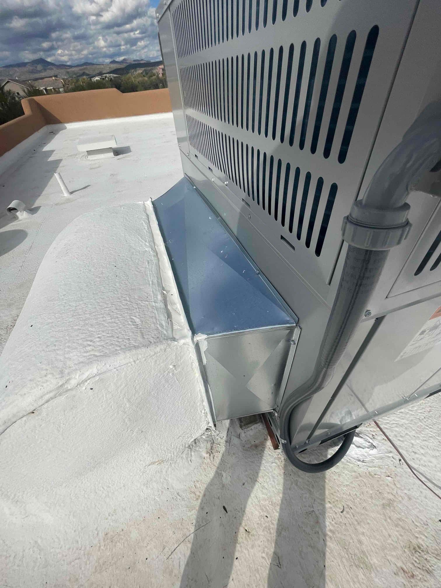New rooftop heat pump set with sealed curb adapter and sealed roof penetration, showing electrical conduit and insulated line set routing.