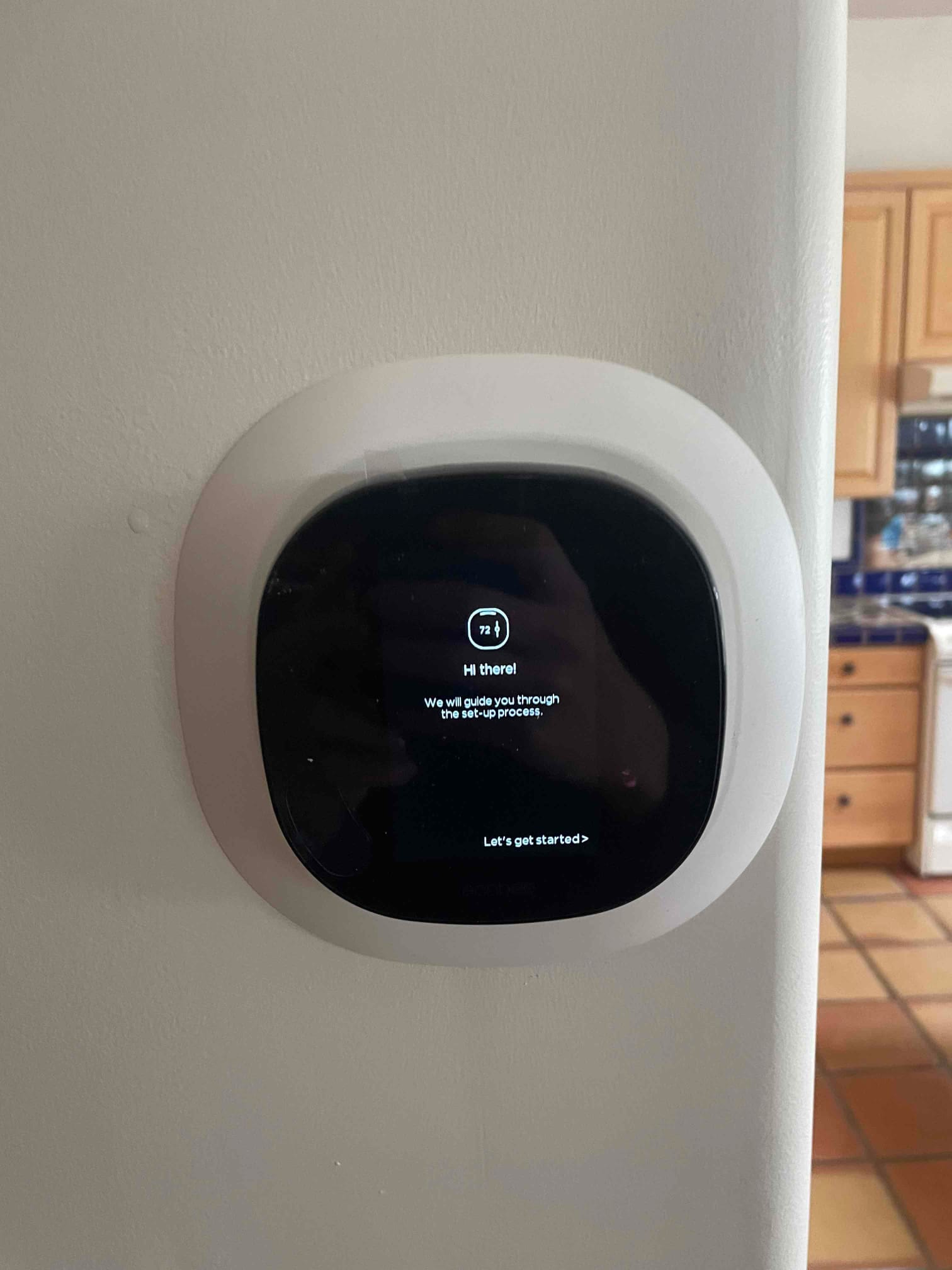New wall-mounted smart thermostat powers up and displays on-screen setup guidance after installation.