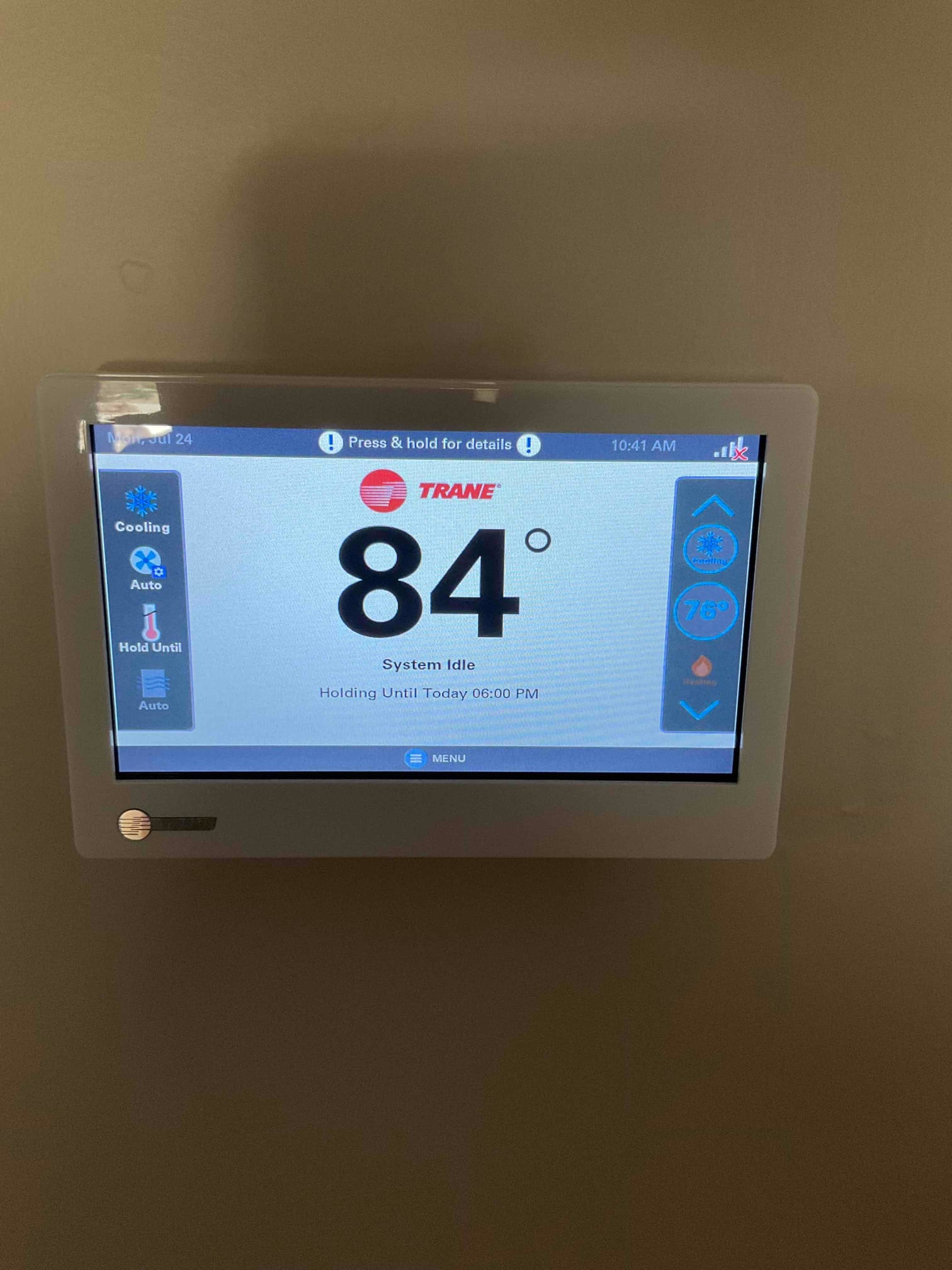 Wall-mounted touchscreen thermostat displays 84 degrees with system status shown as idle after installation.