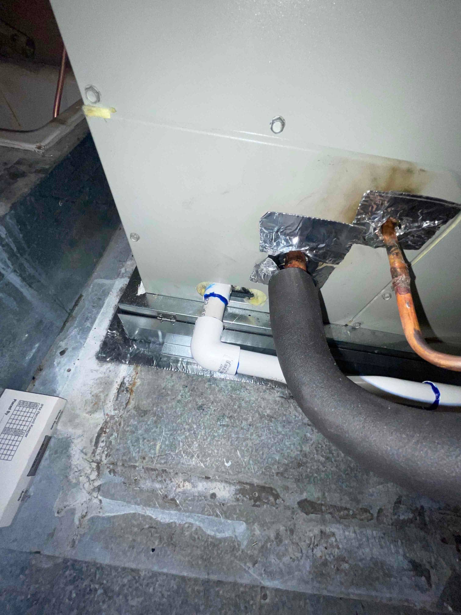 Air handler base with insulated suction line, liquid line, and newly plumbed condensate drain connected to the primary outlet.