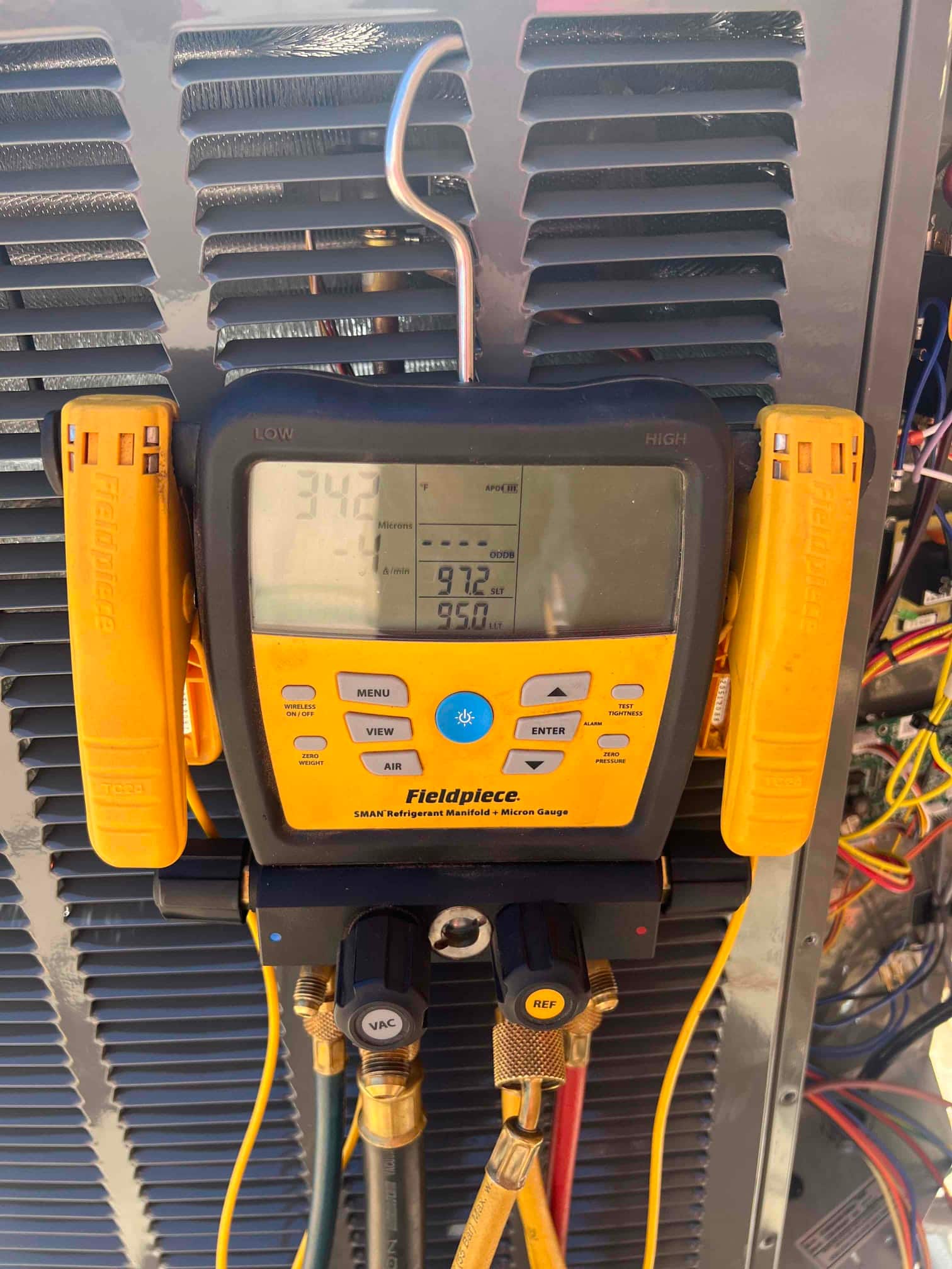 Digital manifold with built-in micron gauge shows 972 microns holding steady during evacuation on the outdoor unit.