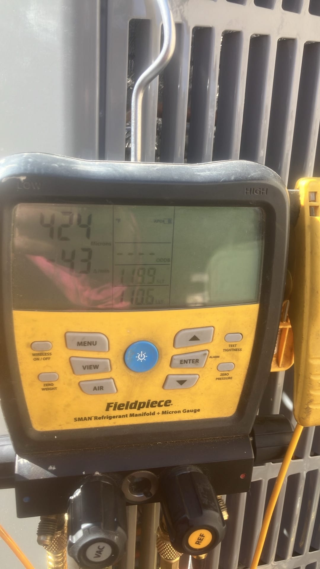 Digital manifold gauges display equal pressures around 424 PSI on both sides during a nitrogen pressure test of the system.