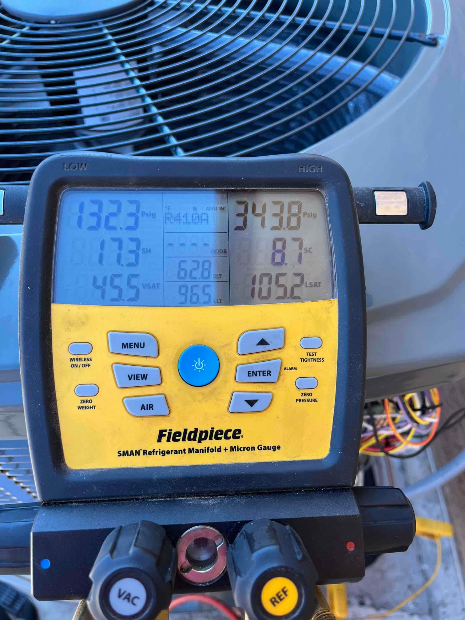Digital manifold on the outdoor unit shows operating pressures with low side at 132 PSI and high side at 343 PSI.