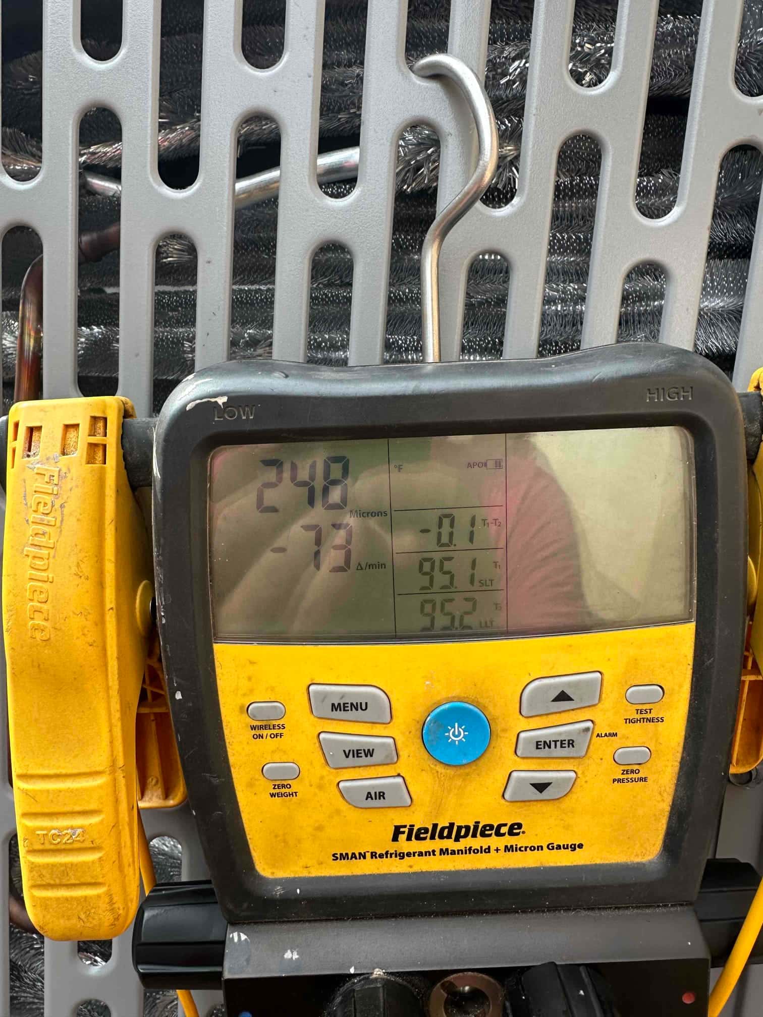 Digital micron gauge on the refrigeration manifold shows 248 microns, documenting a deep vacuum during system evacuation.
