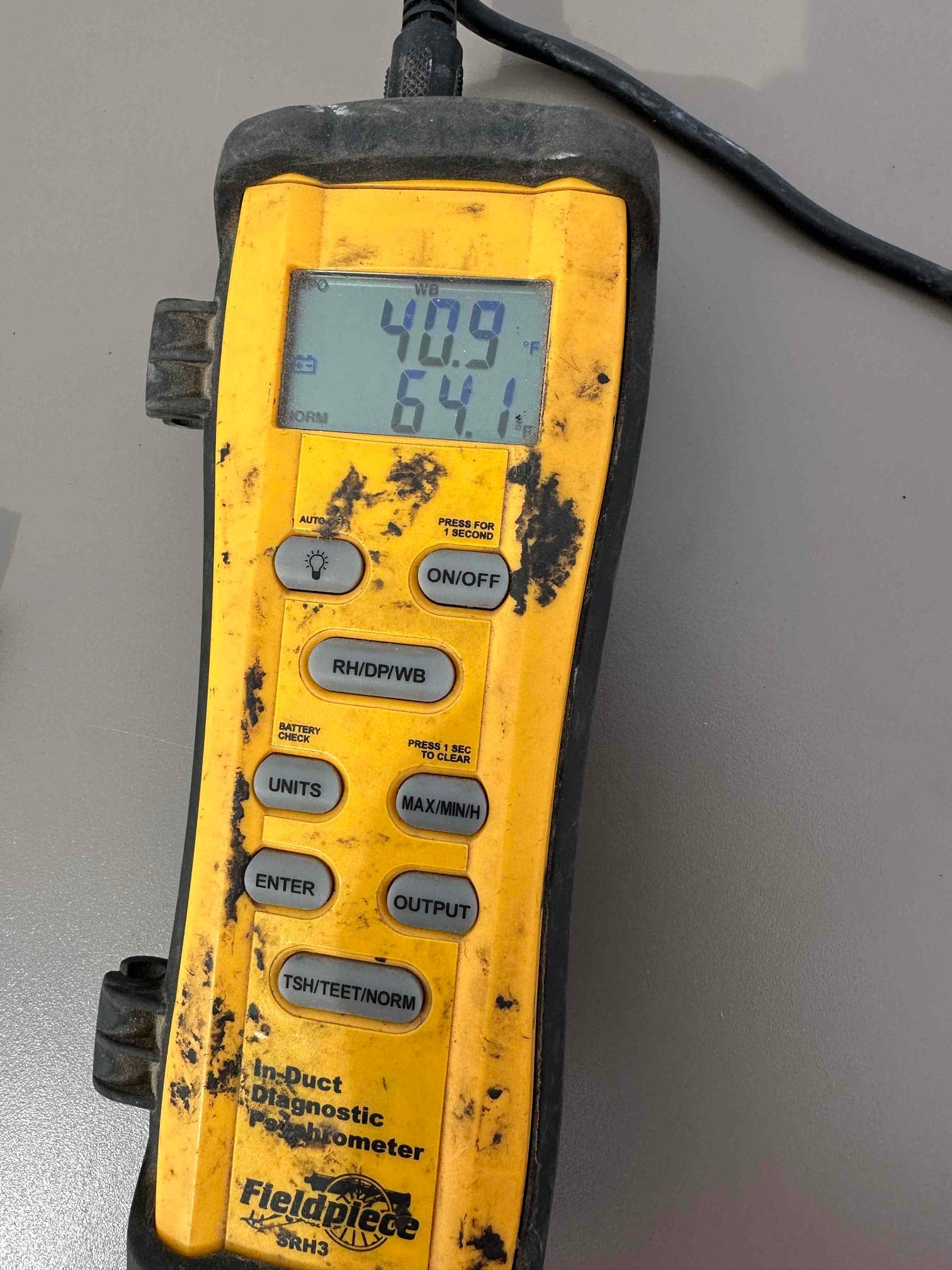 Digital psychrometer displays wet-bulb 40.9°F and dry-bulb 64.1°F during air-side measurements on the new HVAC installation.