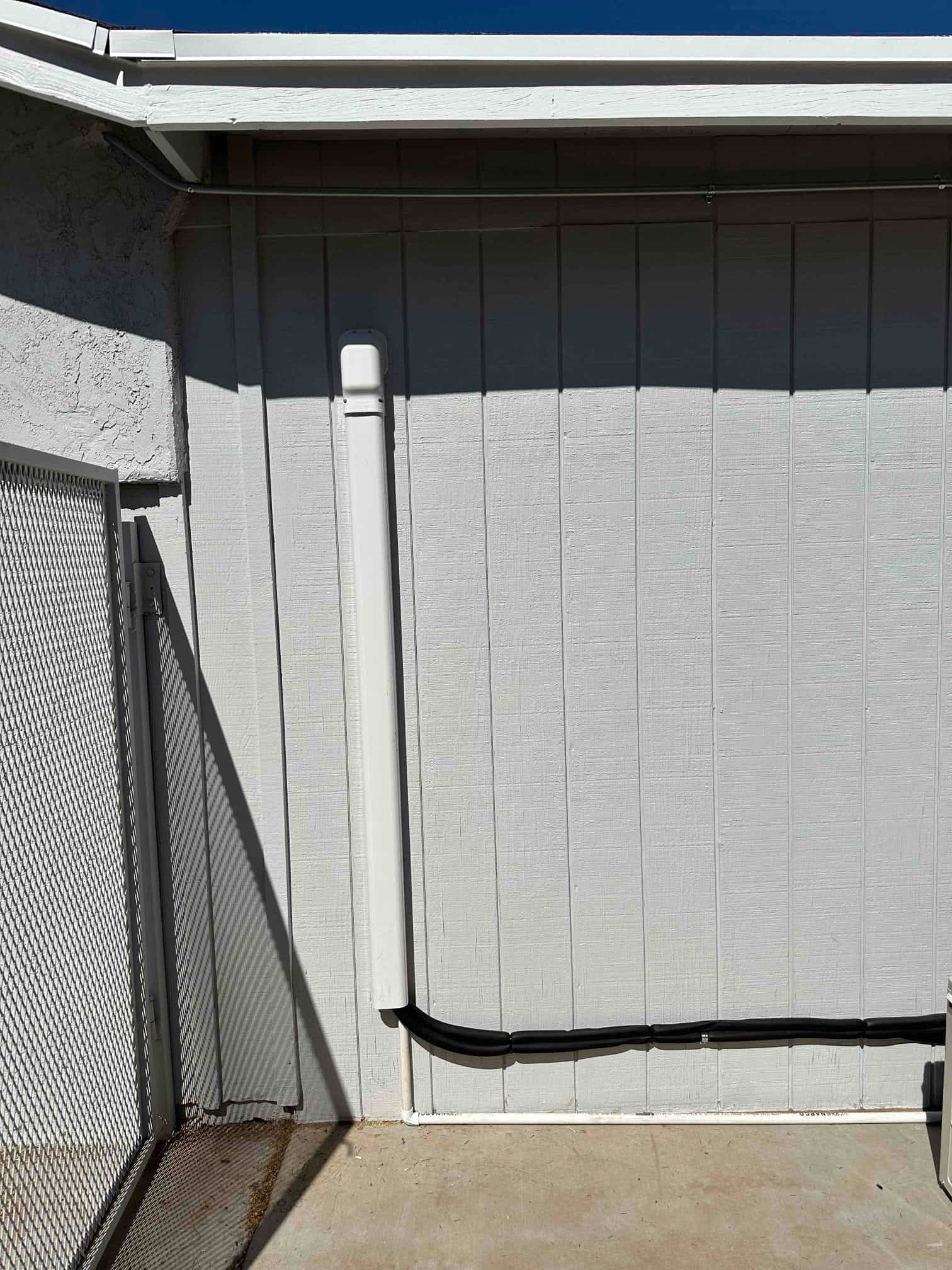 Exterior wall shows new line set cover and insulated refrigerant lines routed neatly to the outdoor mini-split condenser.
