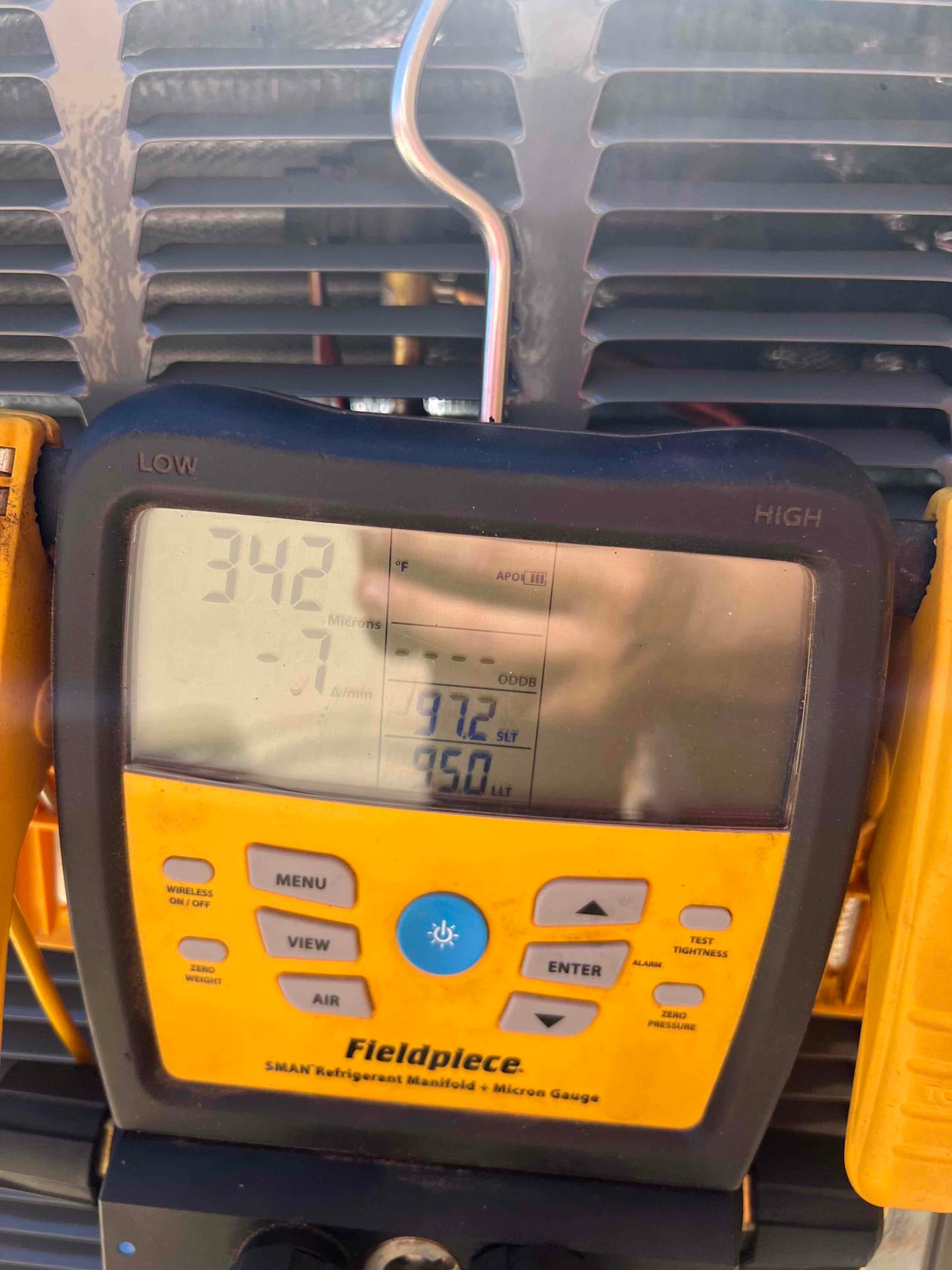 Micron gauge on the outdoor unit reads 342 microns during system evacuation prior to refrigerant charging.