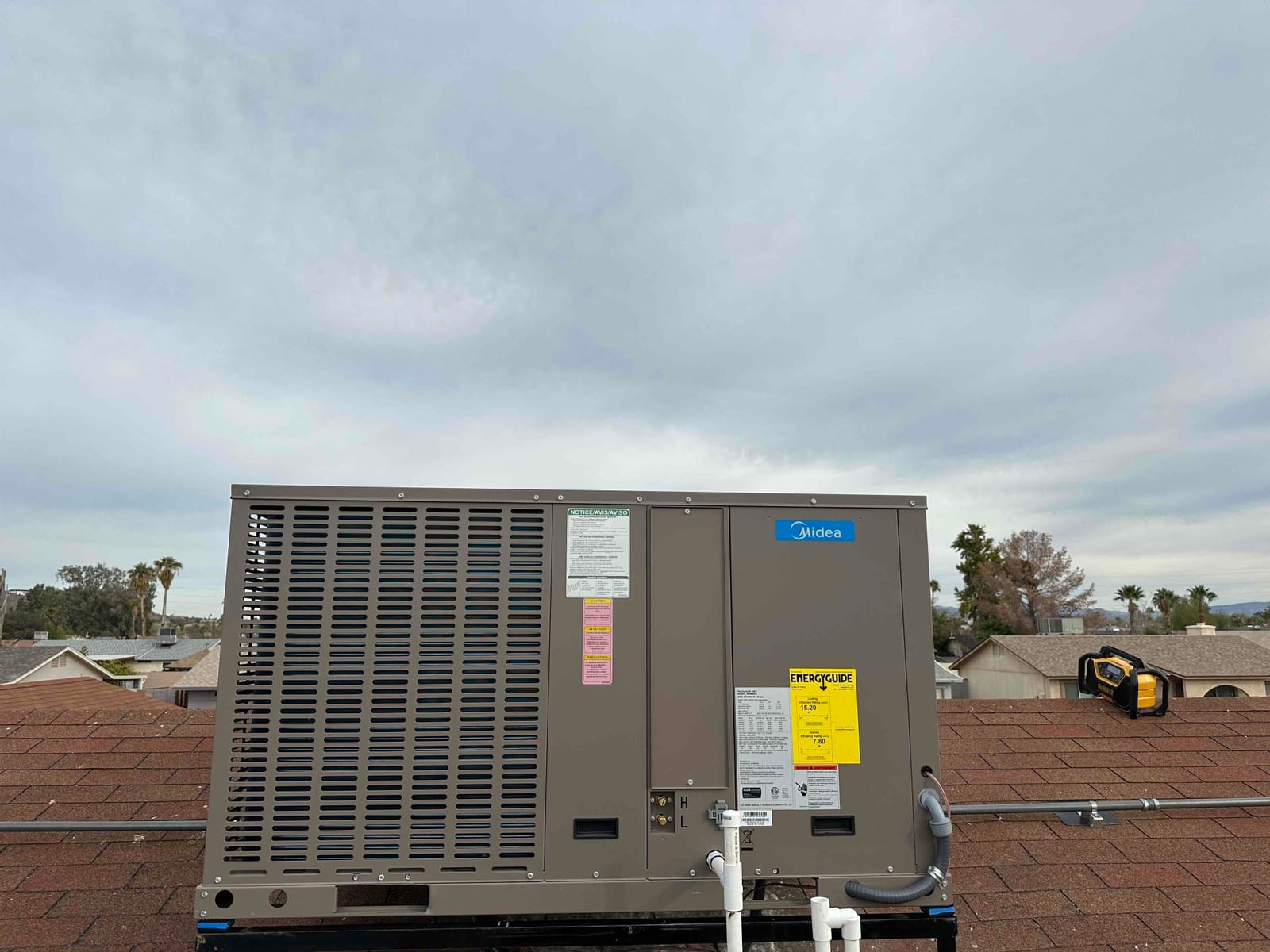 New rooftop package HVAC unit installed on curb with sealed penetrations, electrical conduit, and condensate drain connections visible.