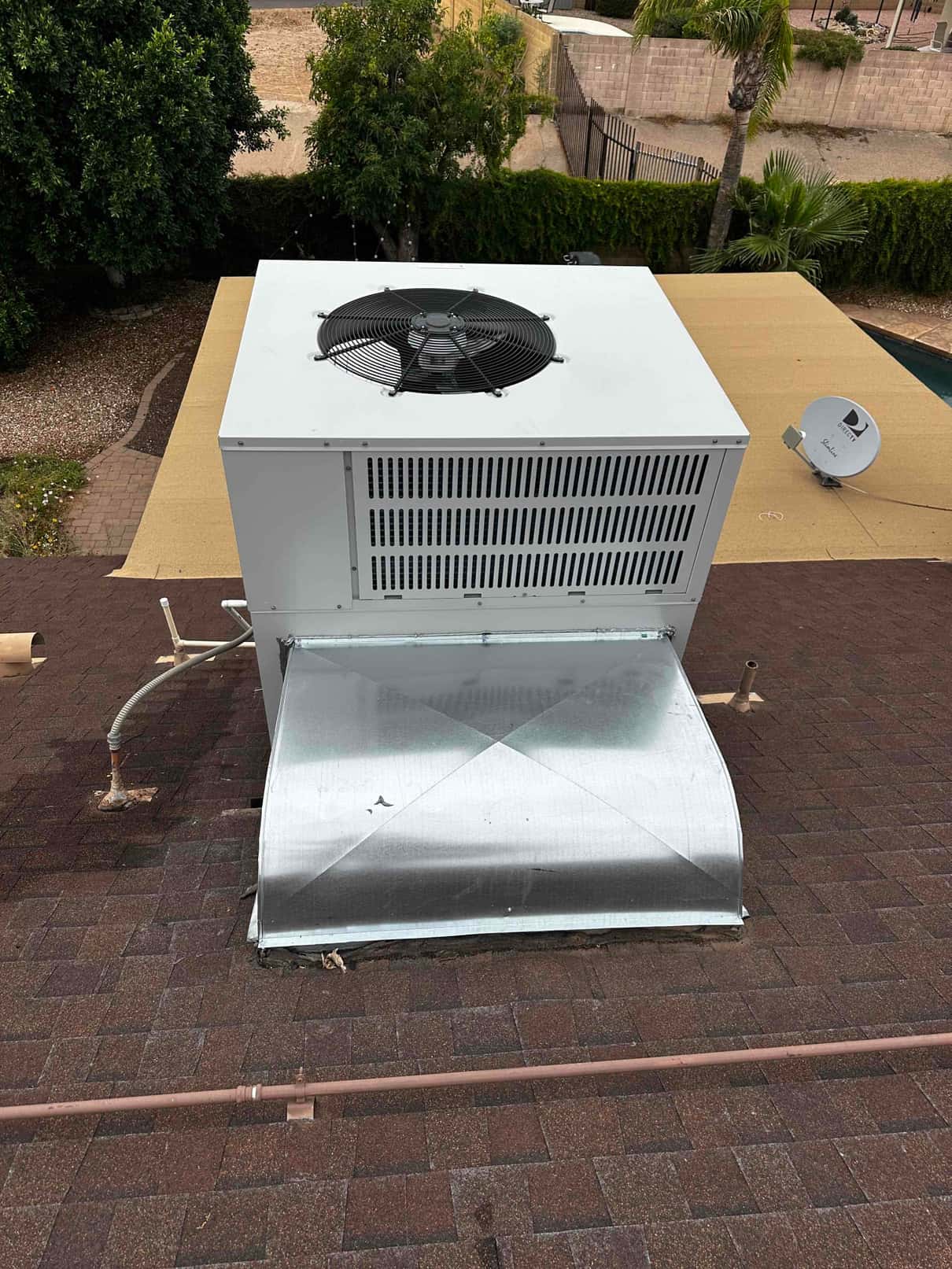 Package HVAC unit set on the rooftop with new sheet-metal curb adapter and sealed duct connection.