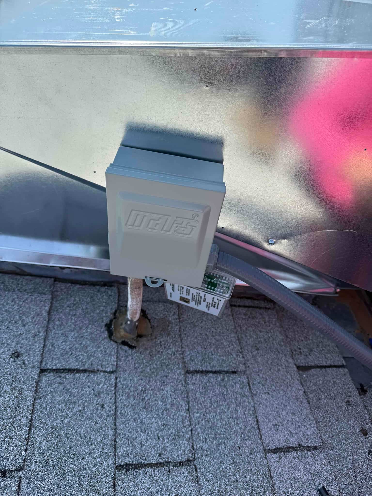 Roof-mounted weatherproof electrical disconnect installed next to the HVAC unit with flexible conduit and sealed roof penetration.
