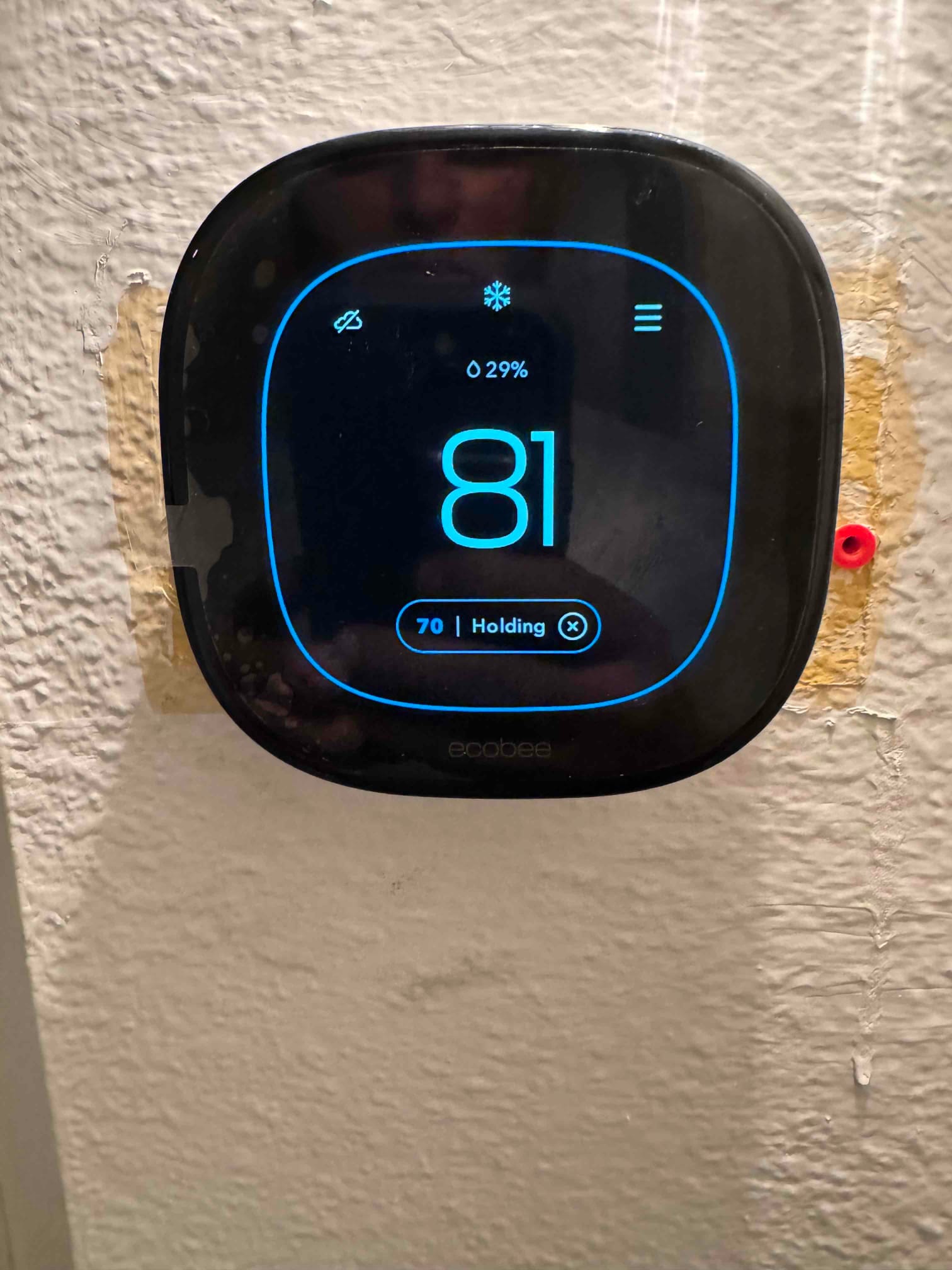 Wall-mounted smart thermostat displays room temperature at 81 degrees with cooling mode active and a setpoint of 70 degrees.