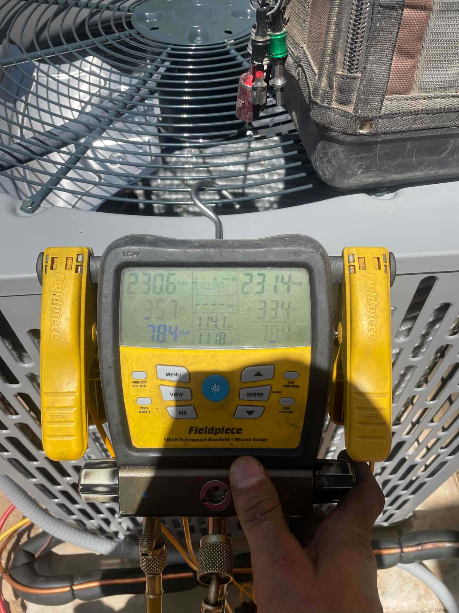 Digital manifold shows equal pressures around 231 PSI on both sides during a nitrogen pressure test at the outdoor unit.