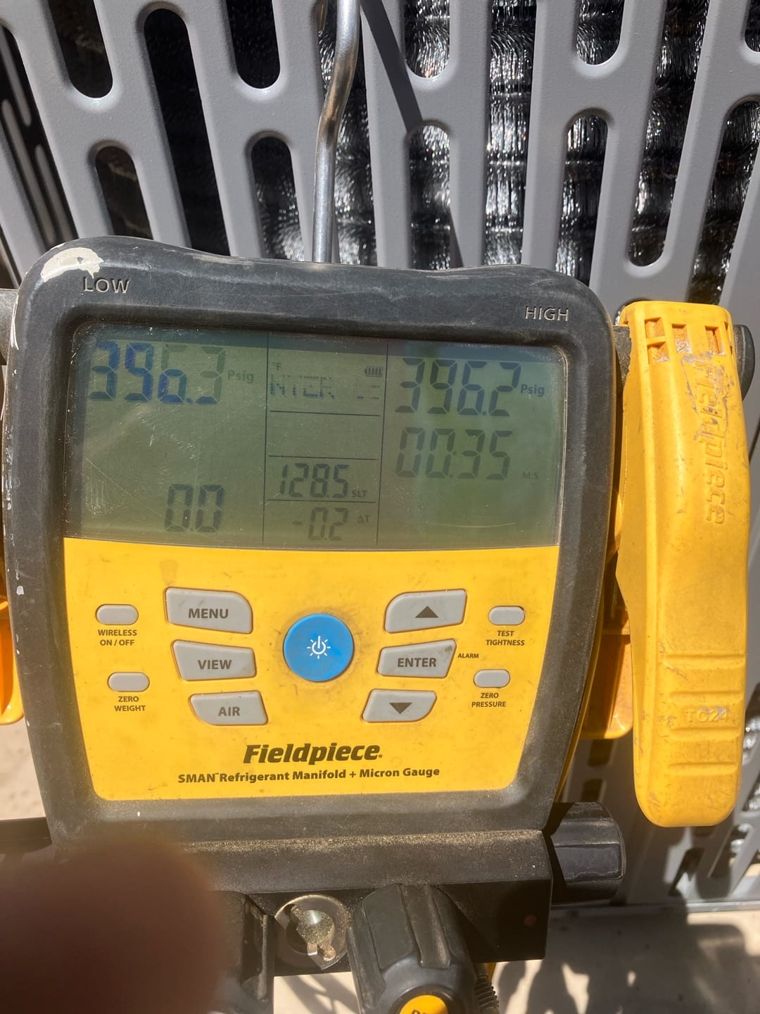 Digital manifold shows equal pressures around 396 PSI on both sides during a nitrogen pressure test at the outdoor unit.