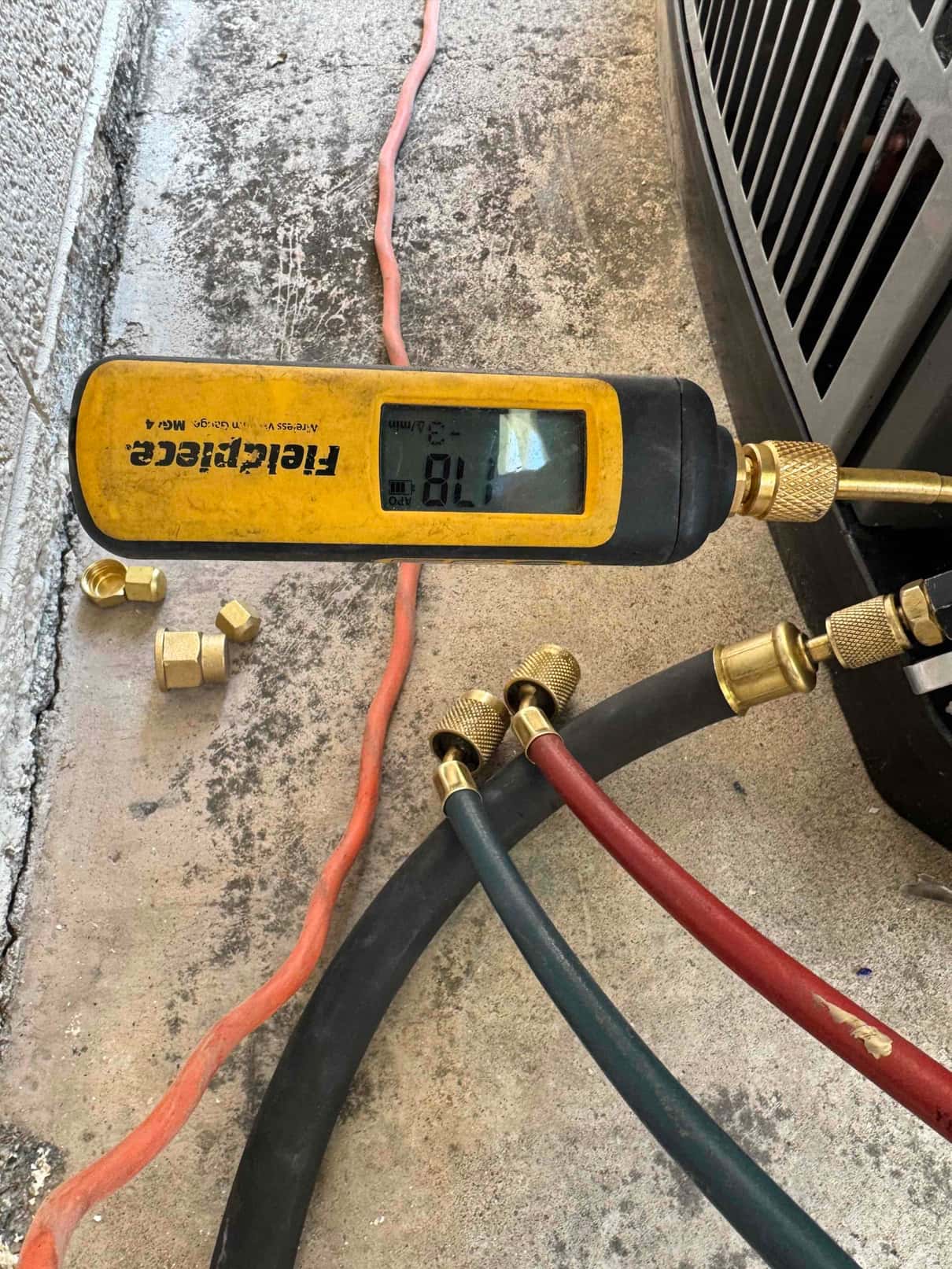 Digital micron gauge connected at the outdoor unit reads 178 microns during the evacuation phase before refrigerant charging.