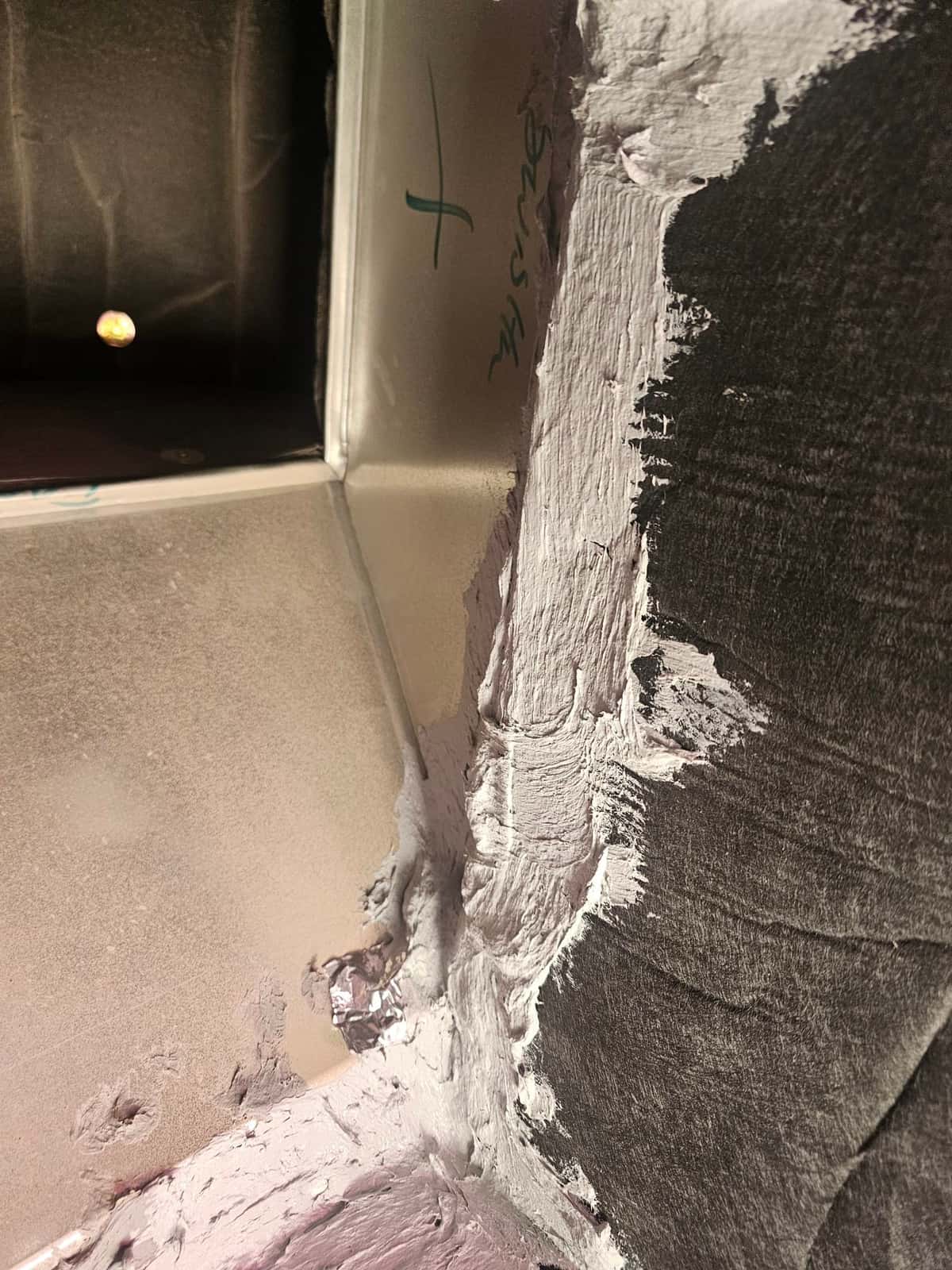 Duct joint sealed with mastic inside the plenum, showing thorough coverage at seams for airtight installation.