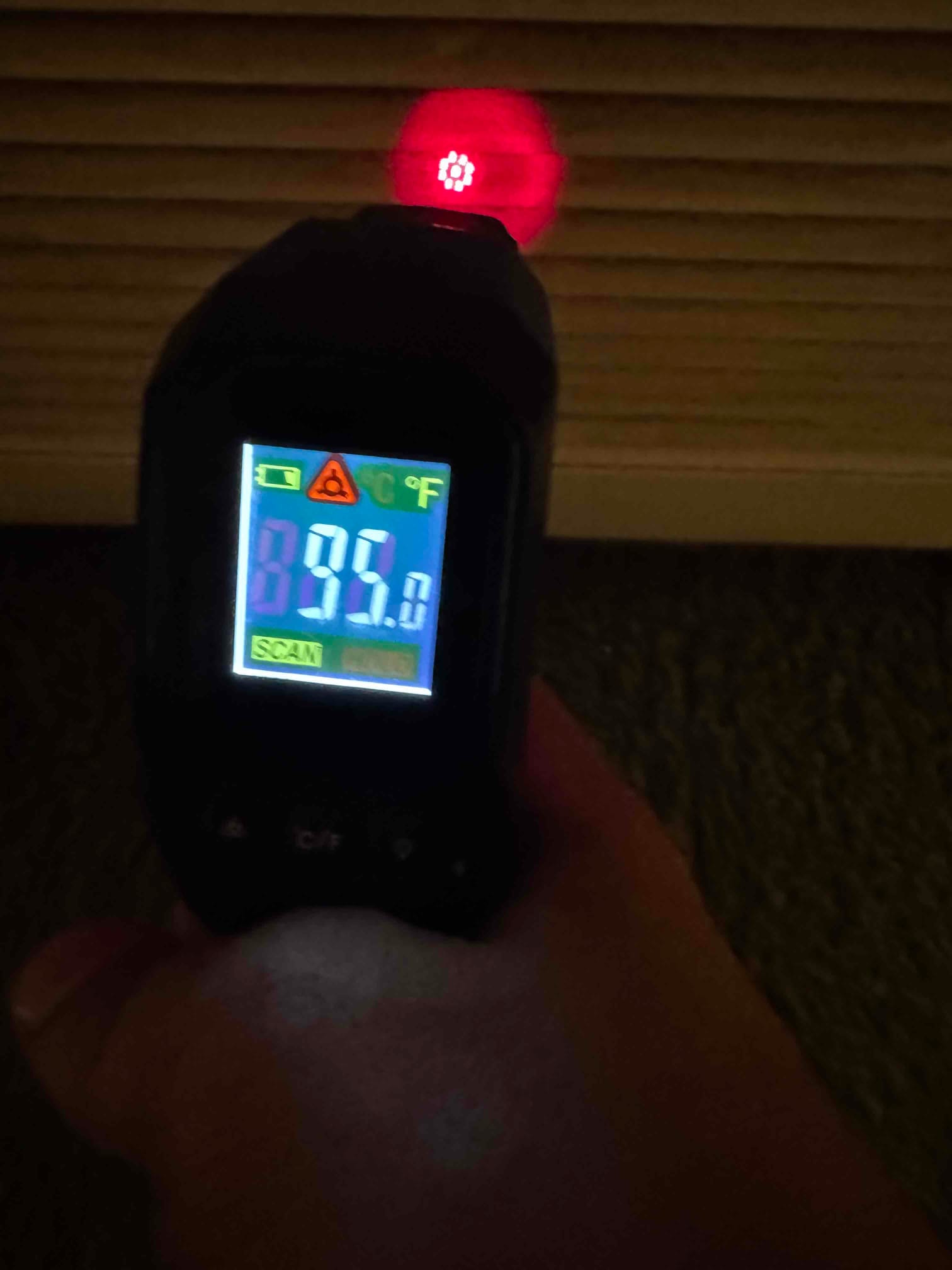 Infrared thermometer measures 85 degrees Fahrenheit at a louvered grille during air temperature check.