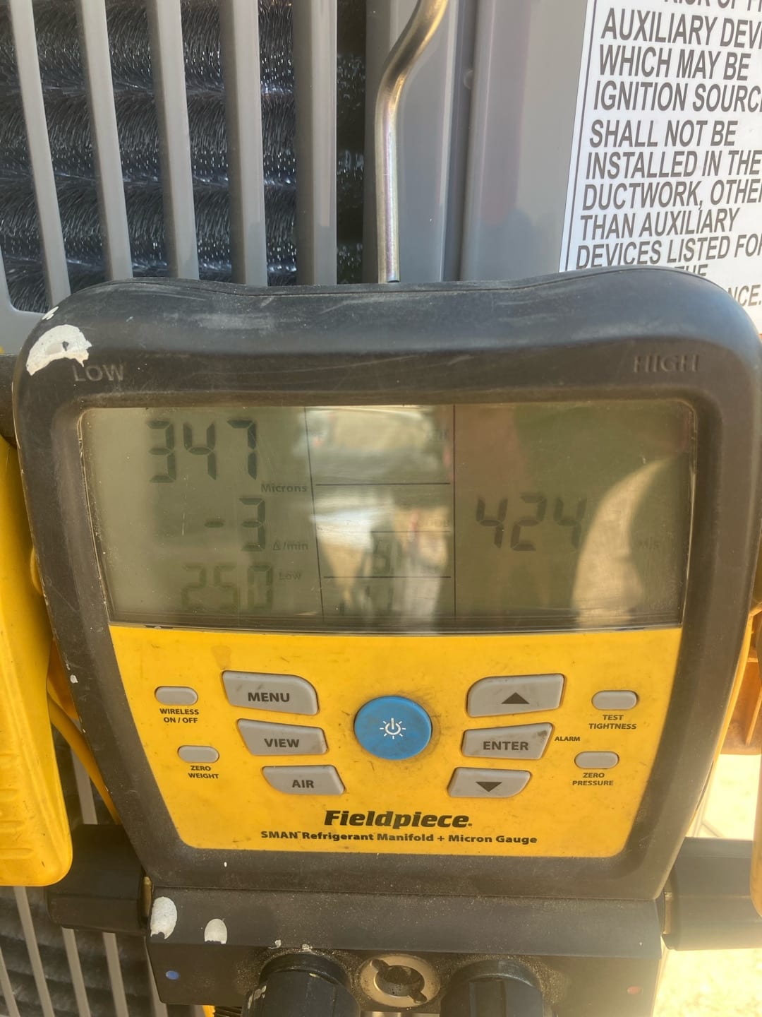 Micron gauge on the manifold shows 347 microns, documenting a deep vacuum during system evacuation before refrigerant charging.