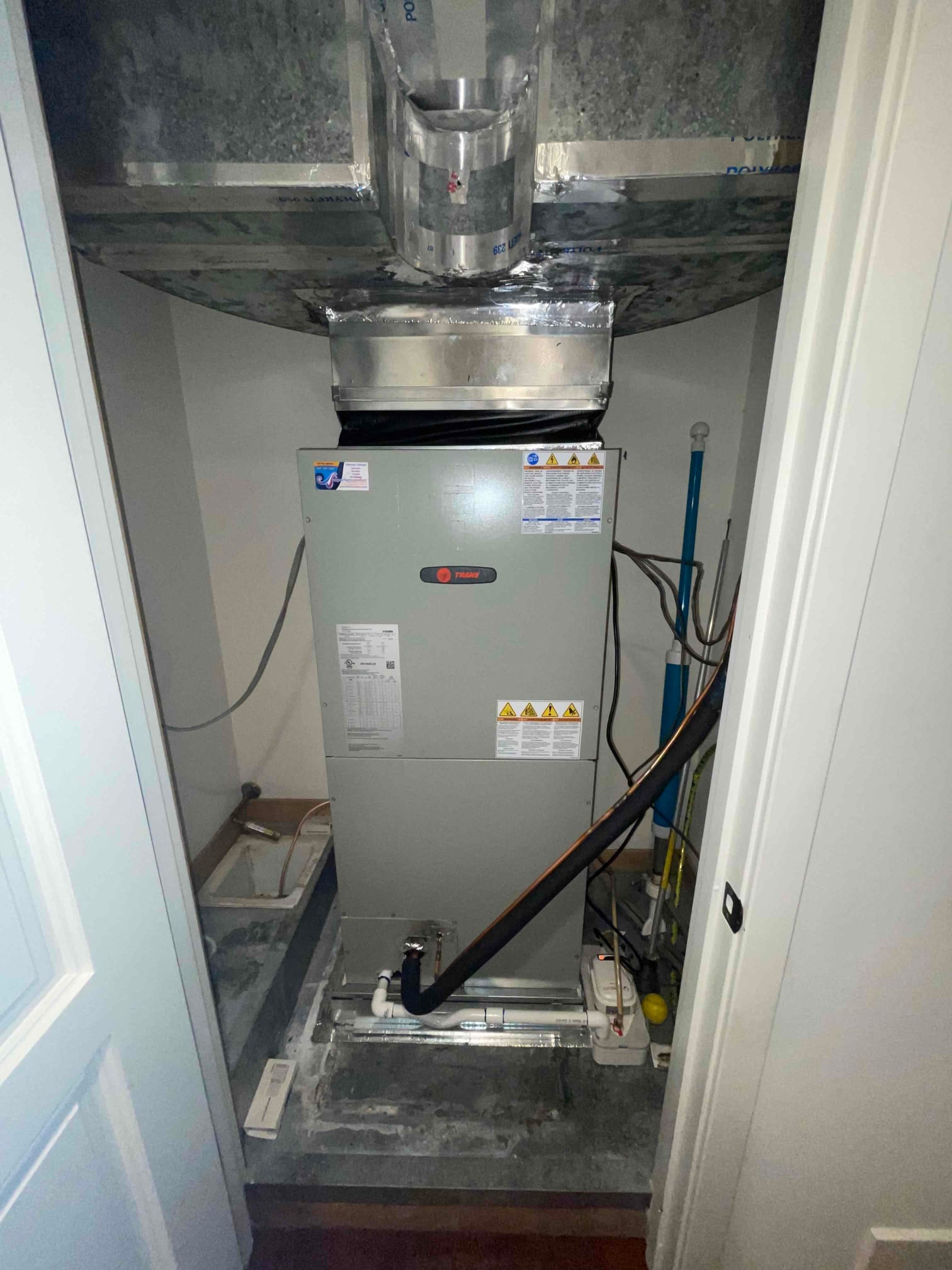 New air handler installed with sealed sheet metal plenum, insulated refrigerant line, condensate drain, and condensate pump set in the closet.