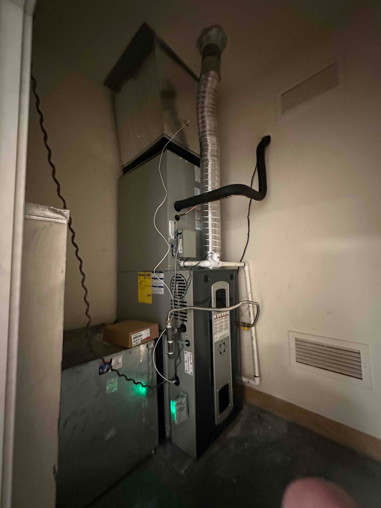 New gas furnace and evaporator coil installed with flue venting, insulated refrigerant line, condensate drain, and connected ductwork.