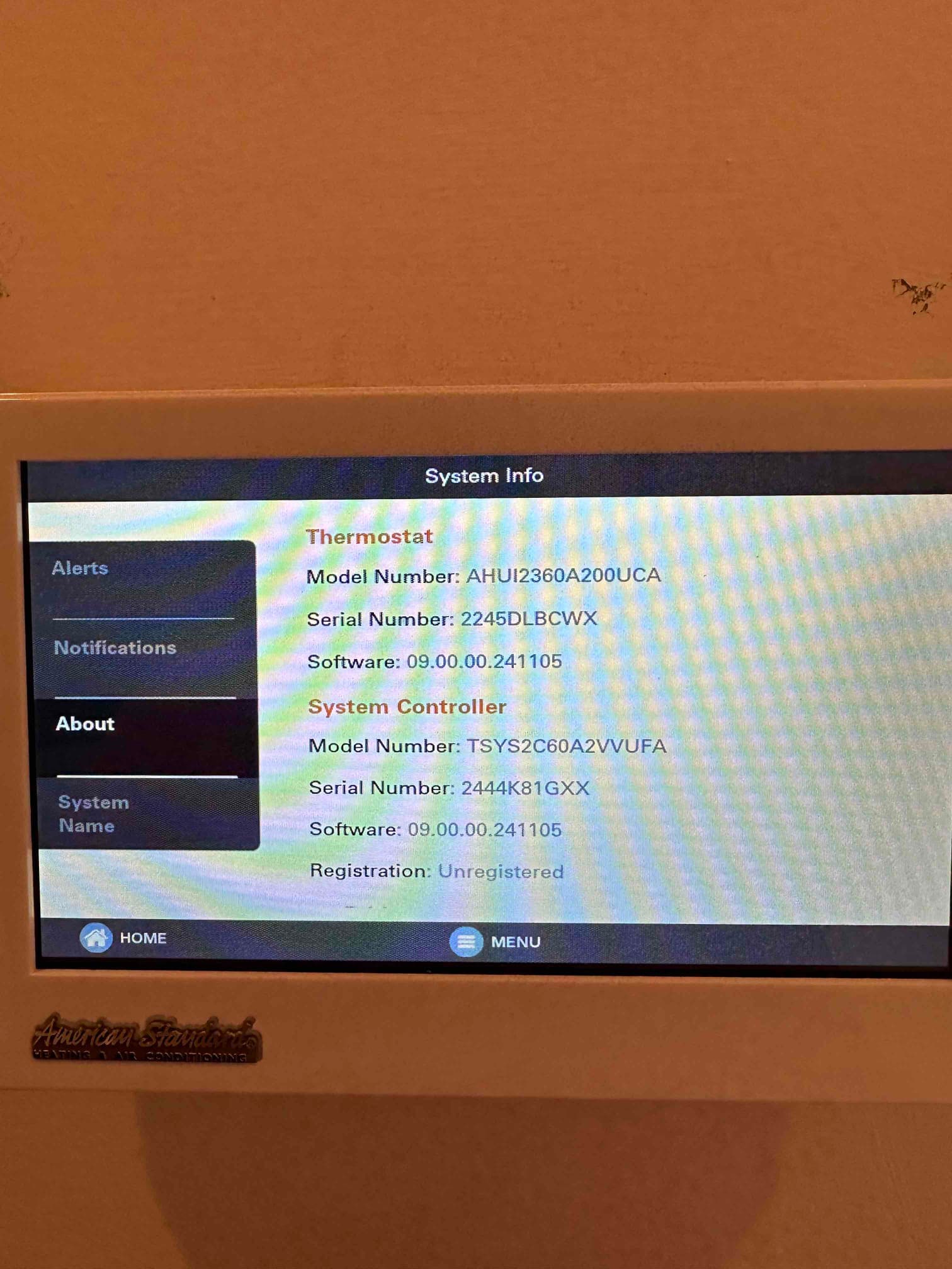 Thermostat touchscreen displays system information and software versions after installation, showing alerts, notifications, and menu options.