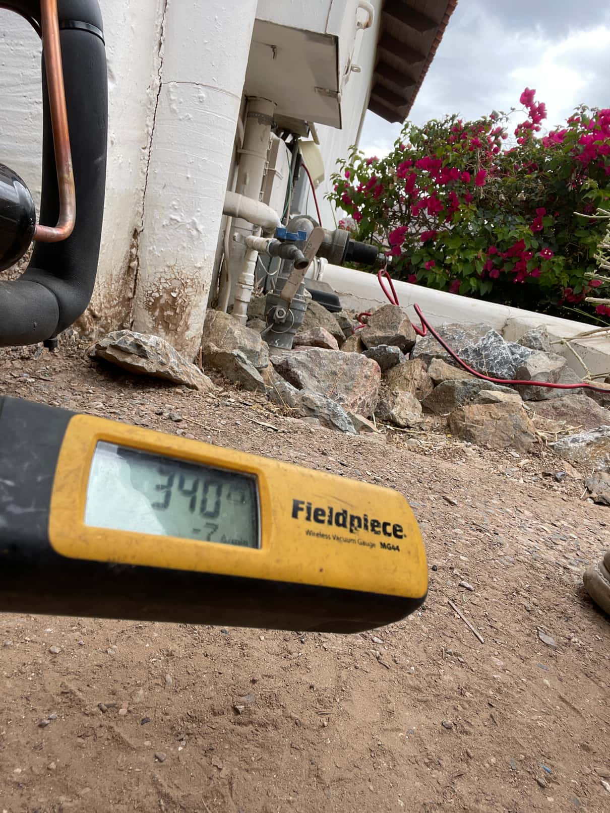 Wireless micron gauge reads 340 microns during vacuum evacuation at the outdoor unit before refrigerant charging.