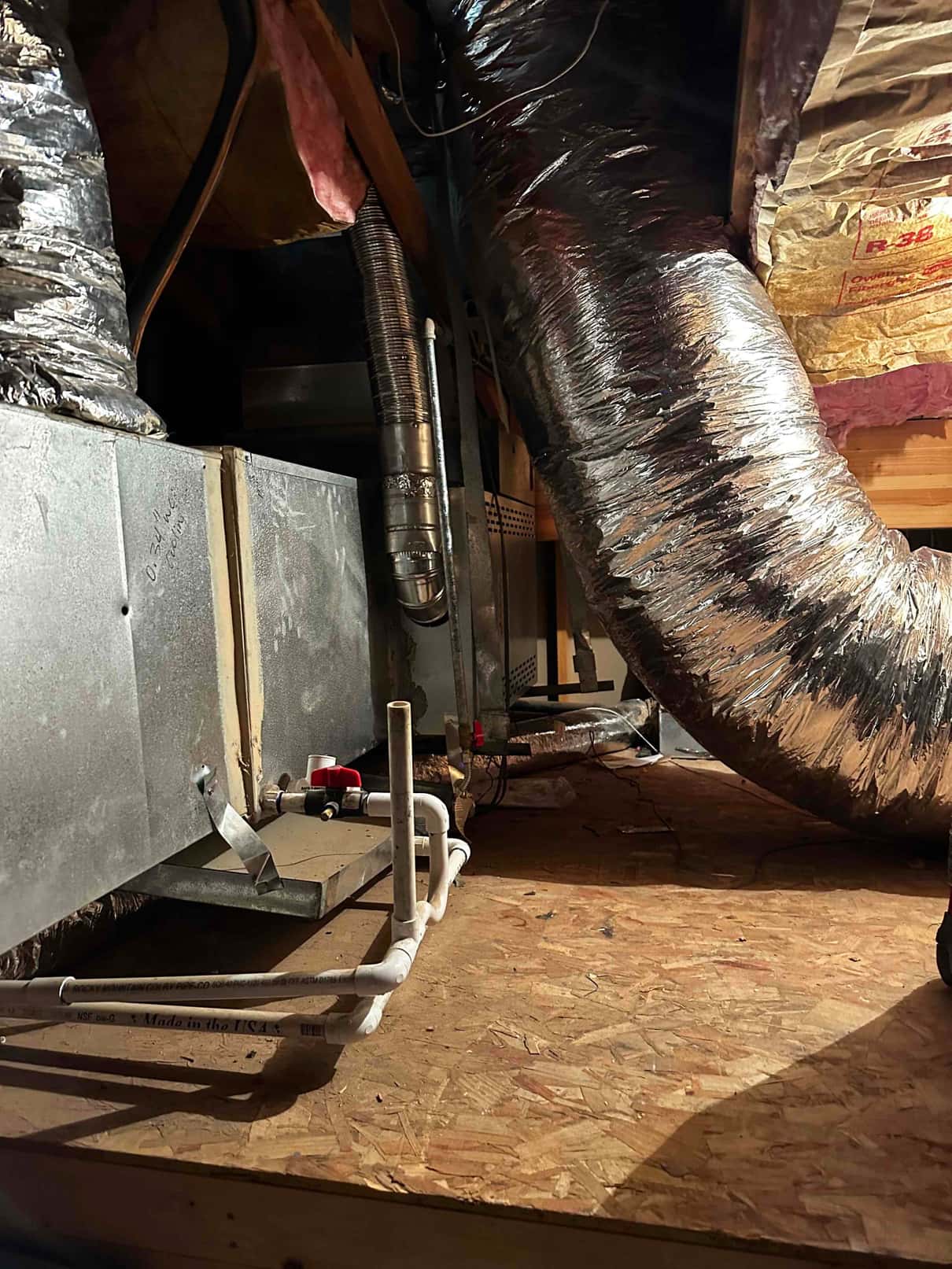Attic air handler installation with insulated flexible duct, PVC condensate drain with cleanout, and new platform decking.