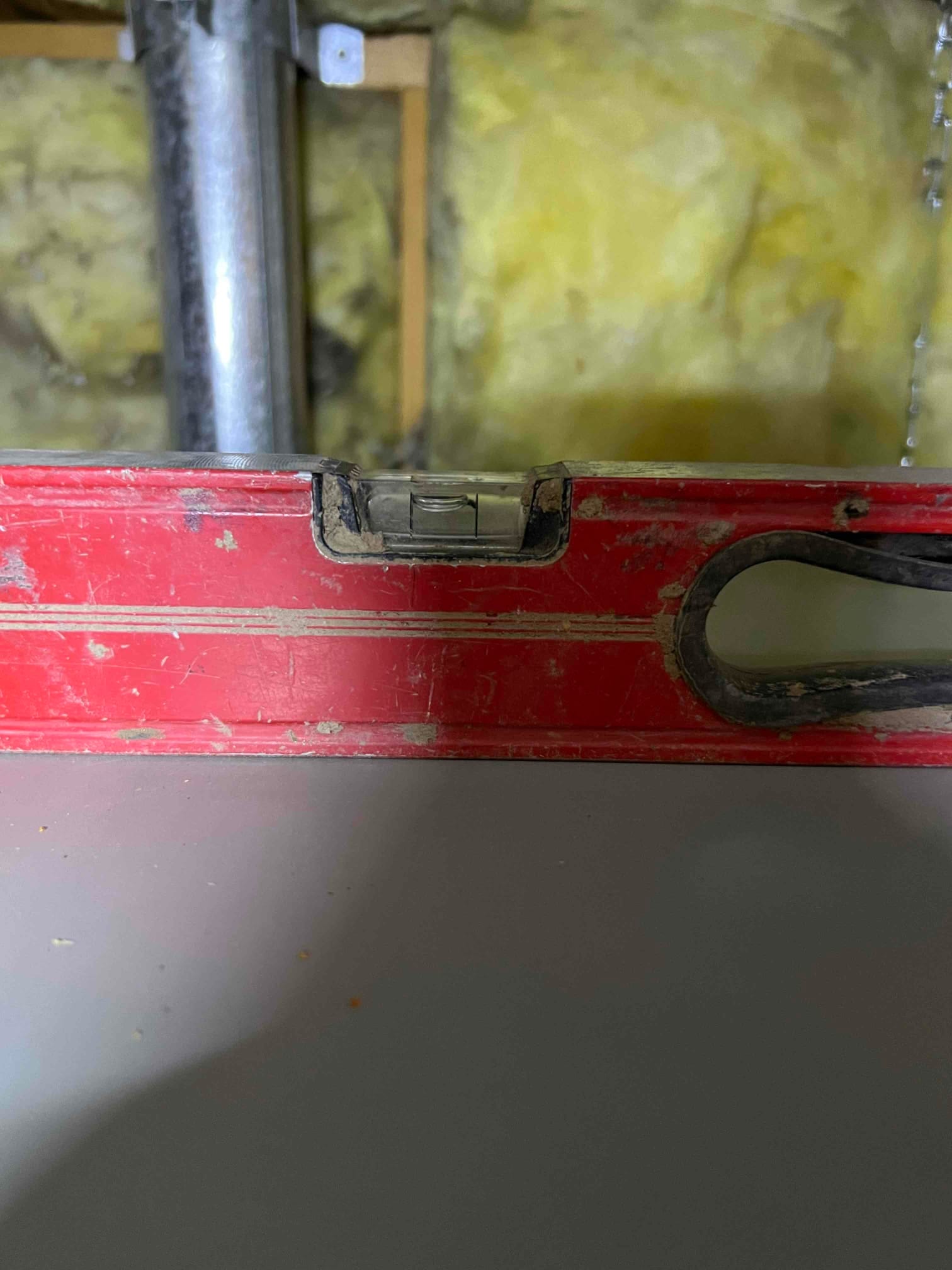 Bubble level placed on top of HVAC equipment cabinet to verify the unit is set perfectly level during installation.