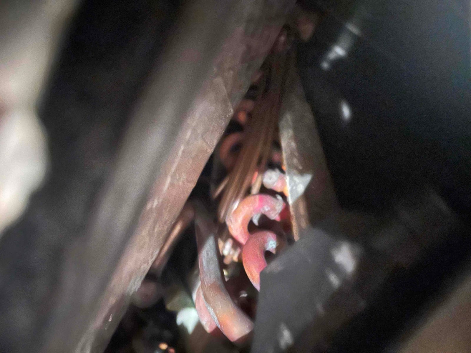 Close-up of corroded copper refrigerant tubing inside an HVAC unit, showing oxidized bends and limited access between surrounding components.