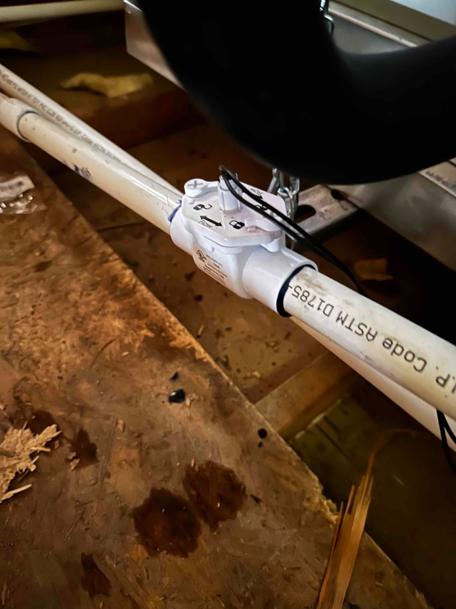 Condensate drain line with an inline safety float switch installed and wired near the air handler.