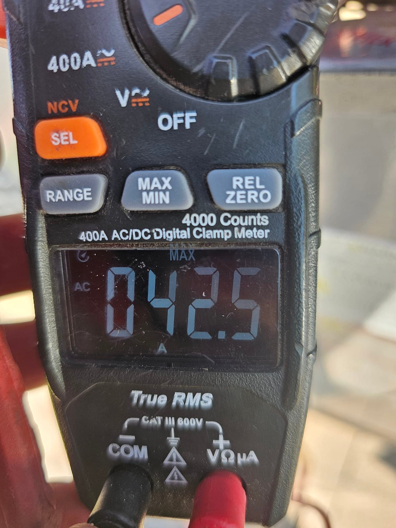 Digital clamp meter display shows 42.5 V AC with test leads connected during air conditioning repair diagnostics.