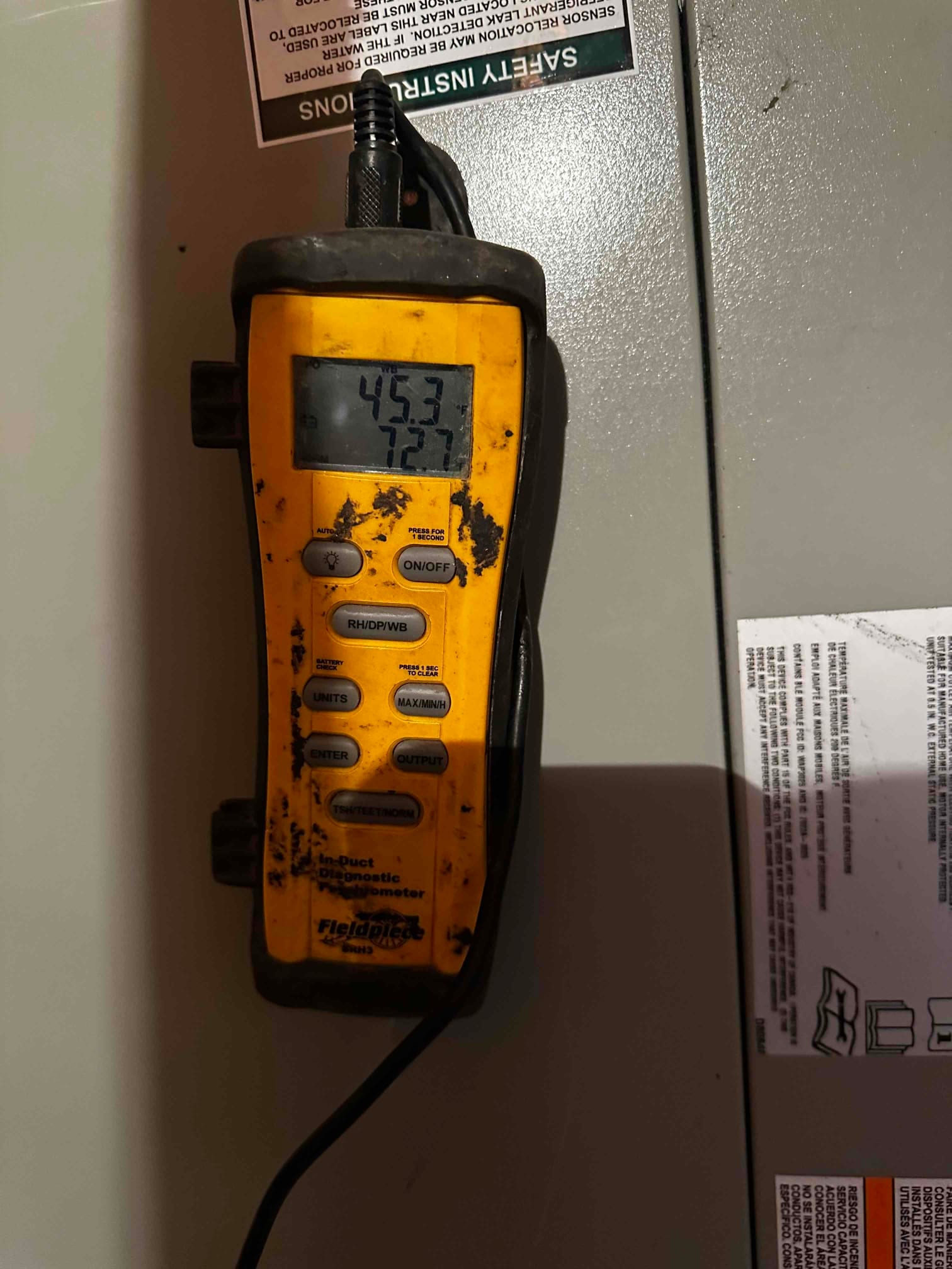 Digital in-duct thermometer shows a temperature reading of 45.3°F, documenting cold supply air during system commissioning.