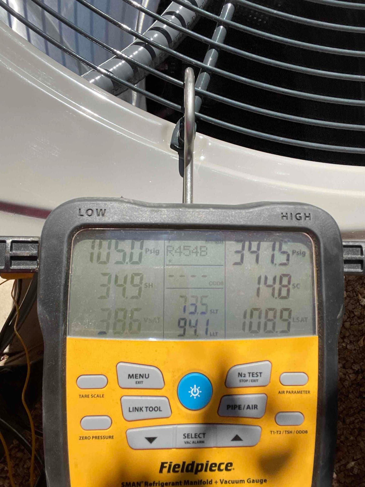 Digital manifold connected at the outdoor unit shows operating pressures and temperatures during system commissioning with refrigerant R-454B.