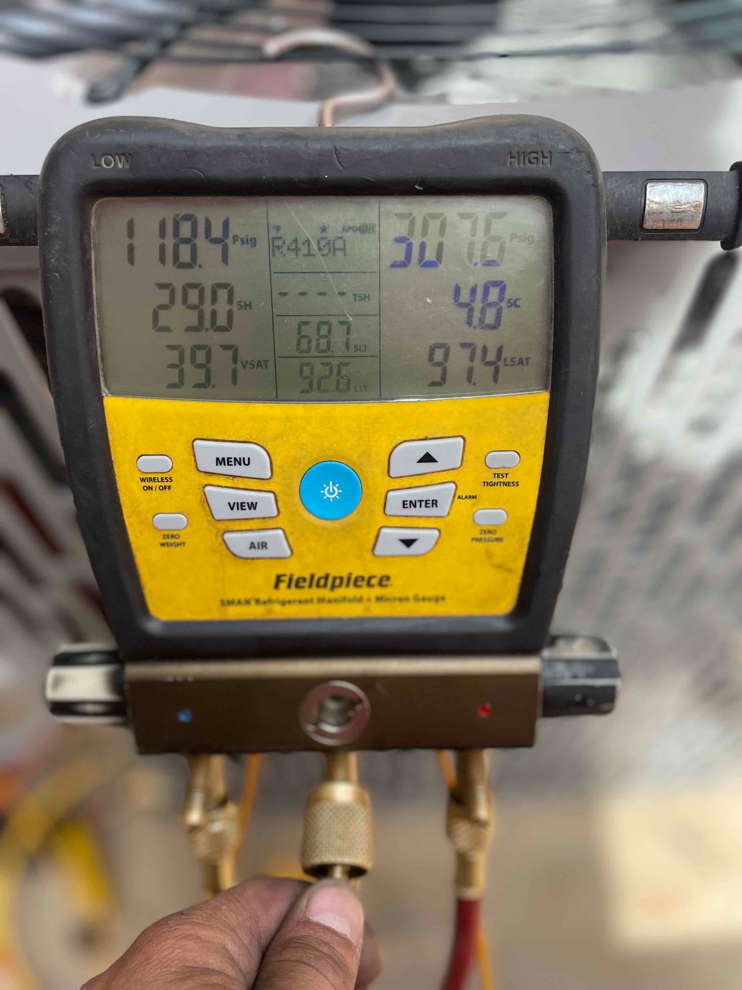Digital manifold displays operating pressures and temperatures while charging the outdoor unit during system commissioning.