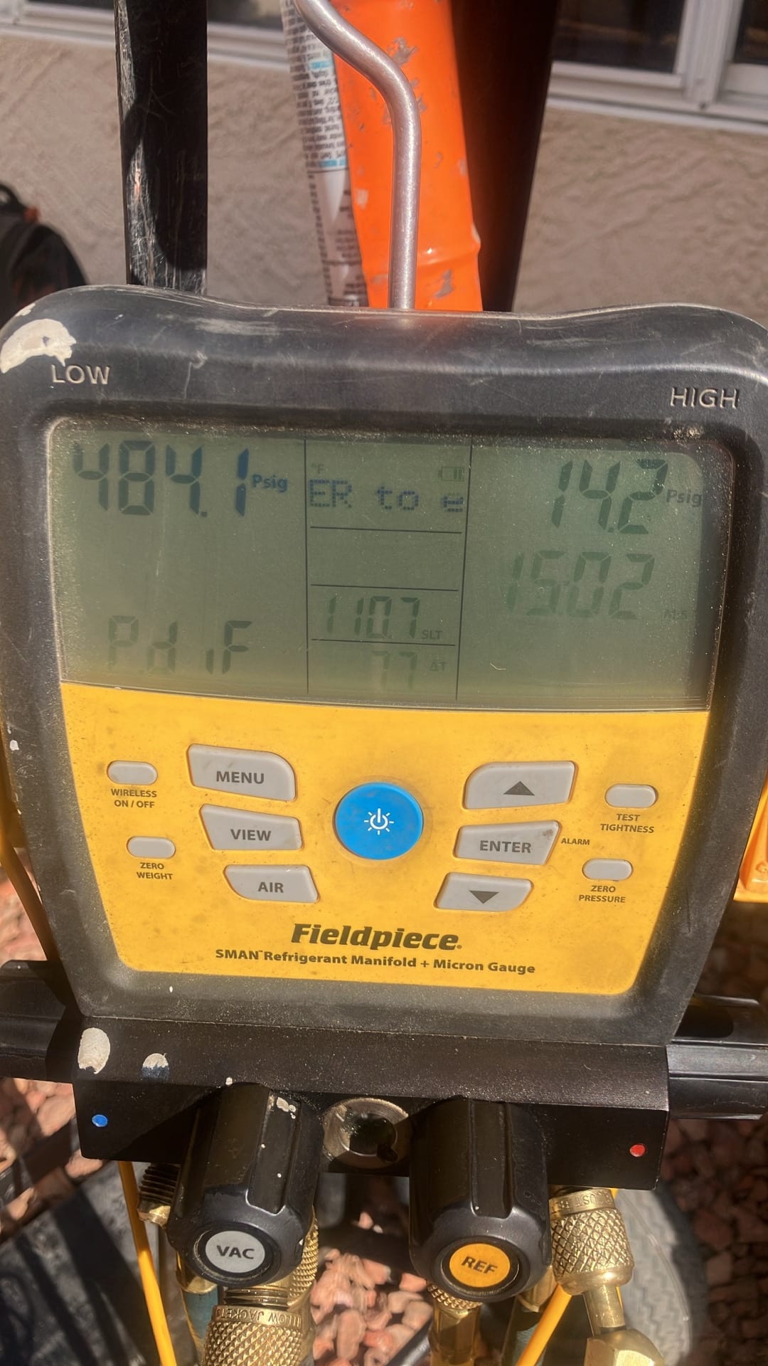 Digital manifold shows operating pressures with low side at 142 PSI and high side at 484 PSI during system run.