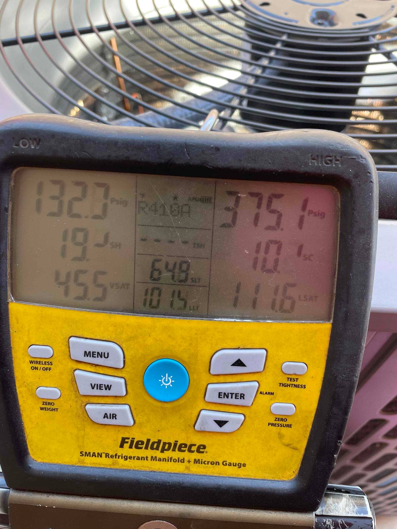 Digital manifold shows system operating with 133 PSI suction and 375 PSI liquid while the outdoor condenser runs.