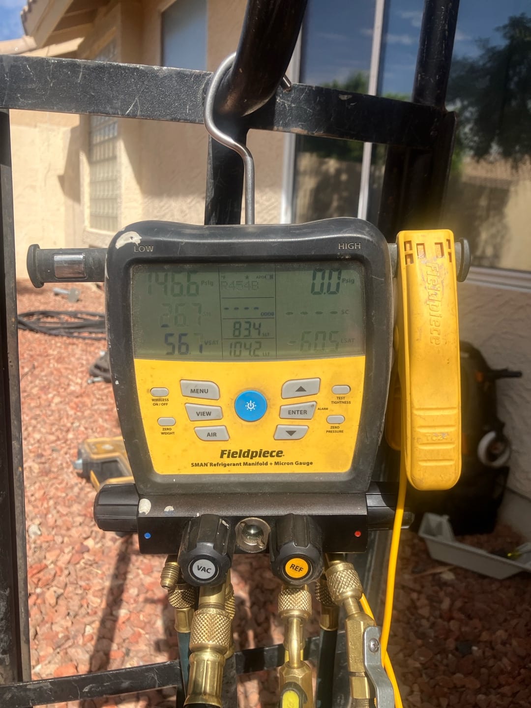 Digital manifold shows system operating with split pressures while commissioning the mini‑split after installation.