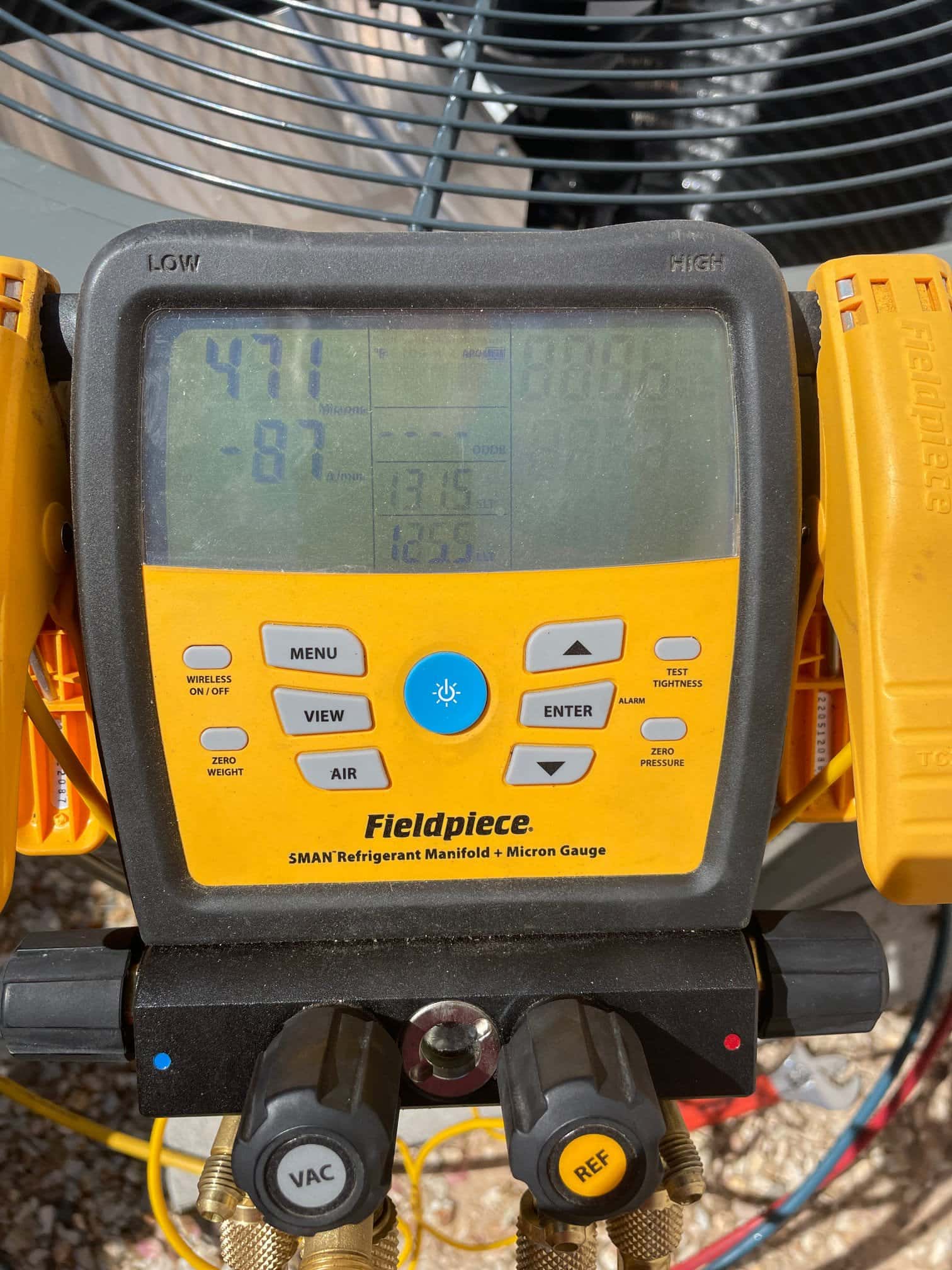 Digital micron gauge on the manifold shows 471 microns during evacuation of the new air conditioning system.