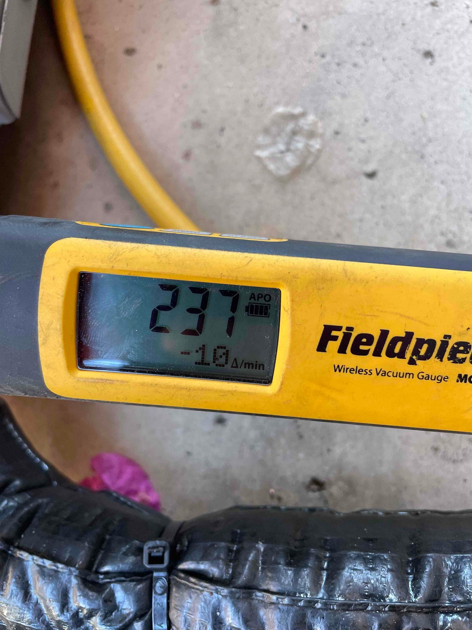 Digital micron gauge shows 237 microns during system evacuation, confirming a deep vacuum before refrigerant charging.