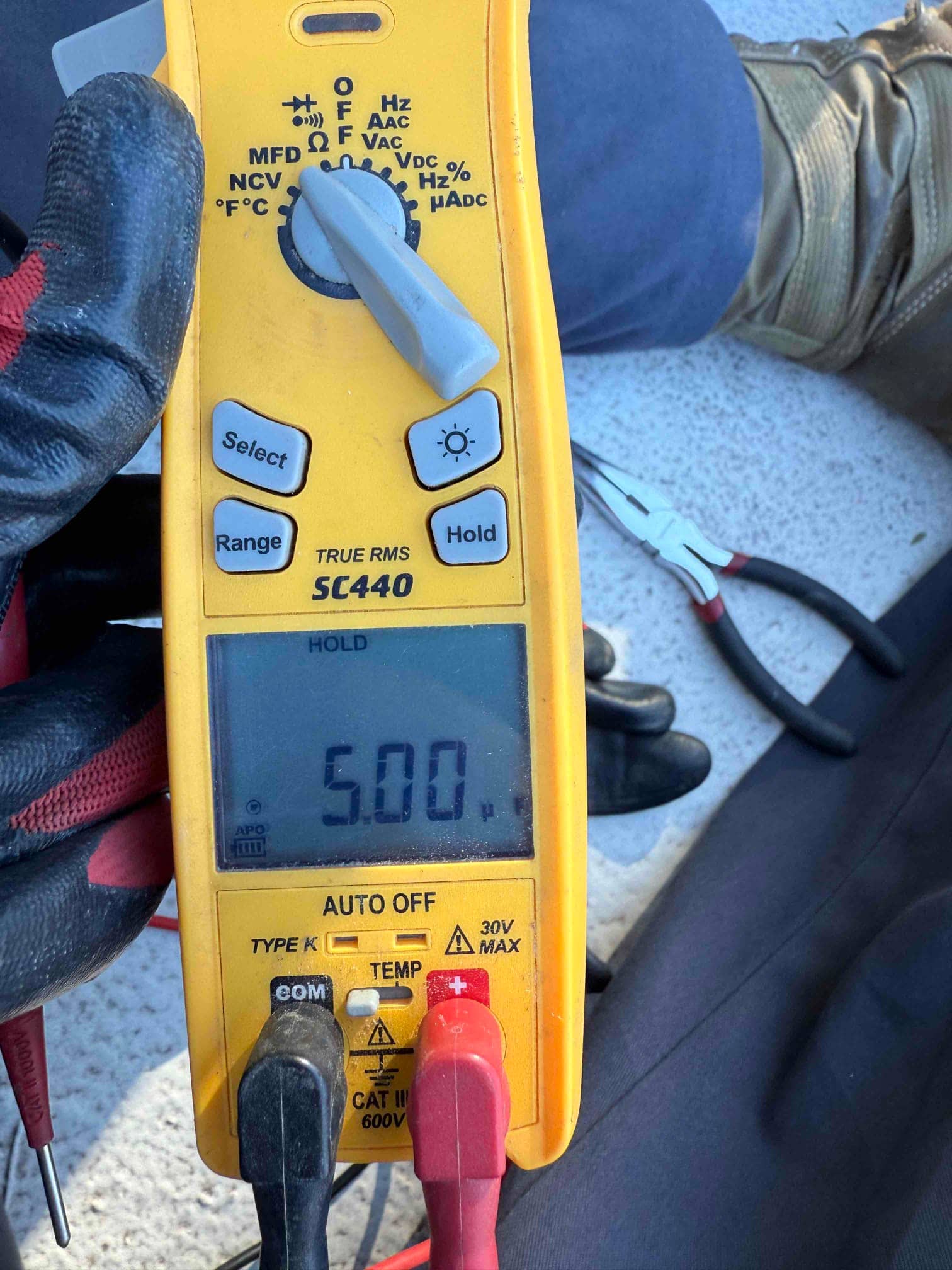Digital multimeter displays 5.00 V while measuring with red and black probes attached to the meter.