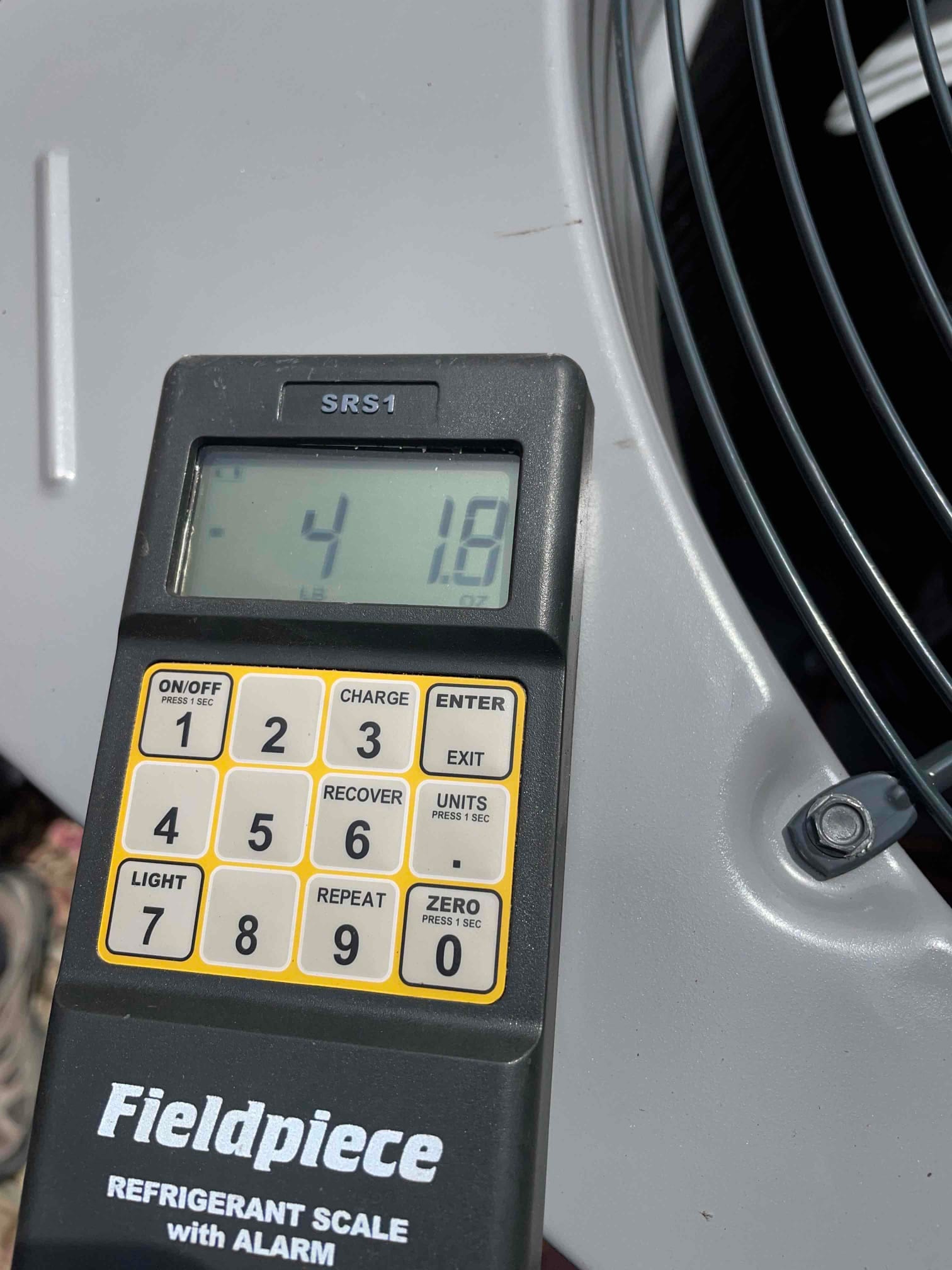 Digital refrigerant scale on top of the outdoor unit shows the charge amount during system commissioning.