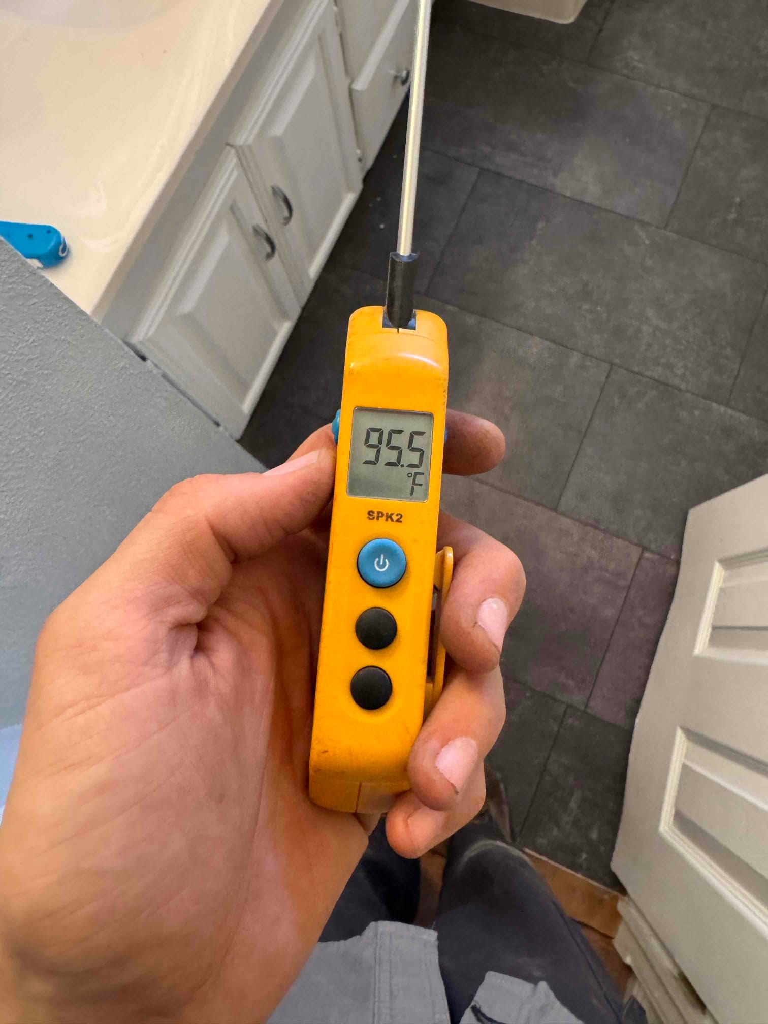 Digital thermometer displays 95.5 °F with the metal probe inserted, used to measure temperature during air conditioning diagnostics.