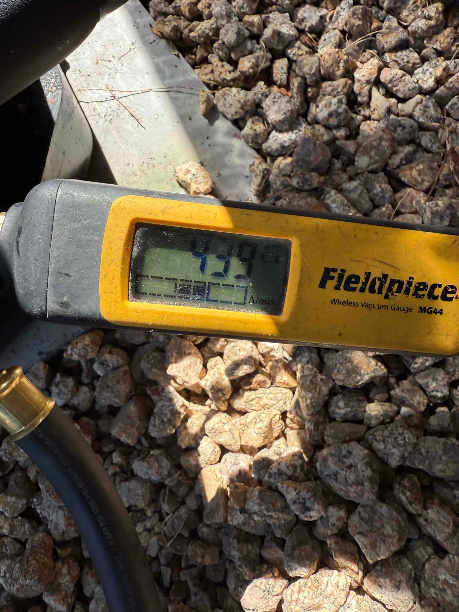 Digital vacuum gauge displays 435 microns, documenting a deep evacuation prior to refrigerant charging on the new system.