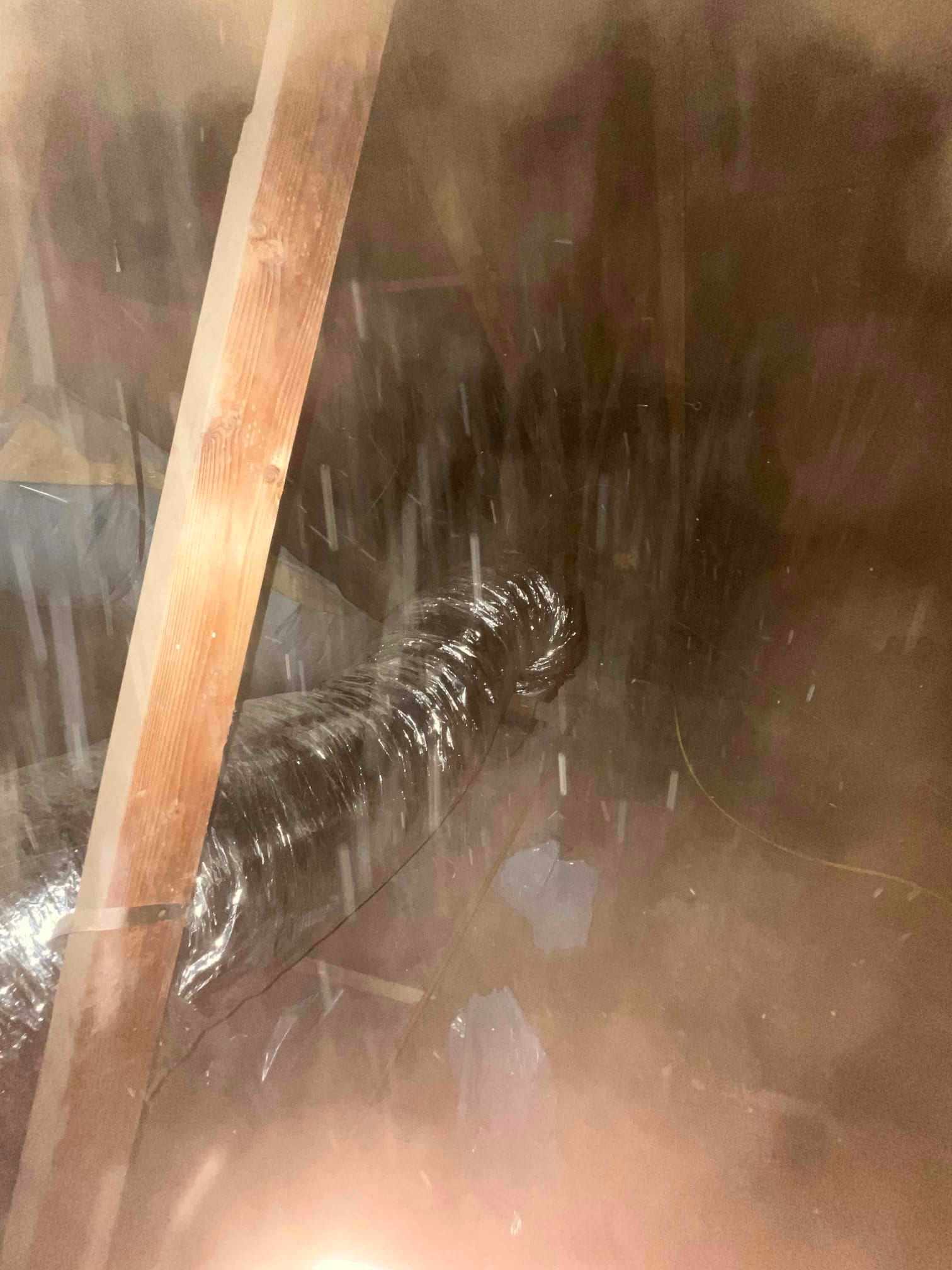 Flexible insulated duct routed through the attic, supported between framing members during the new HVAC installation.