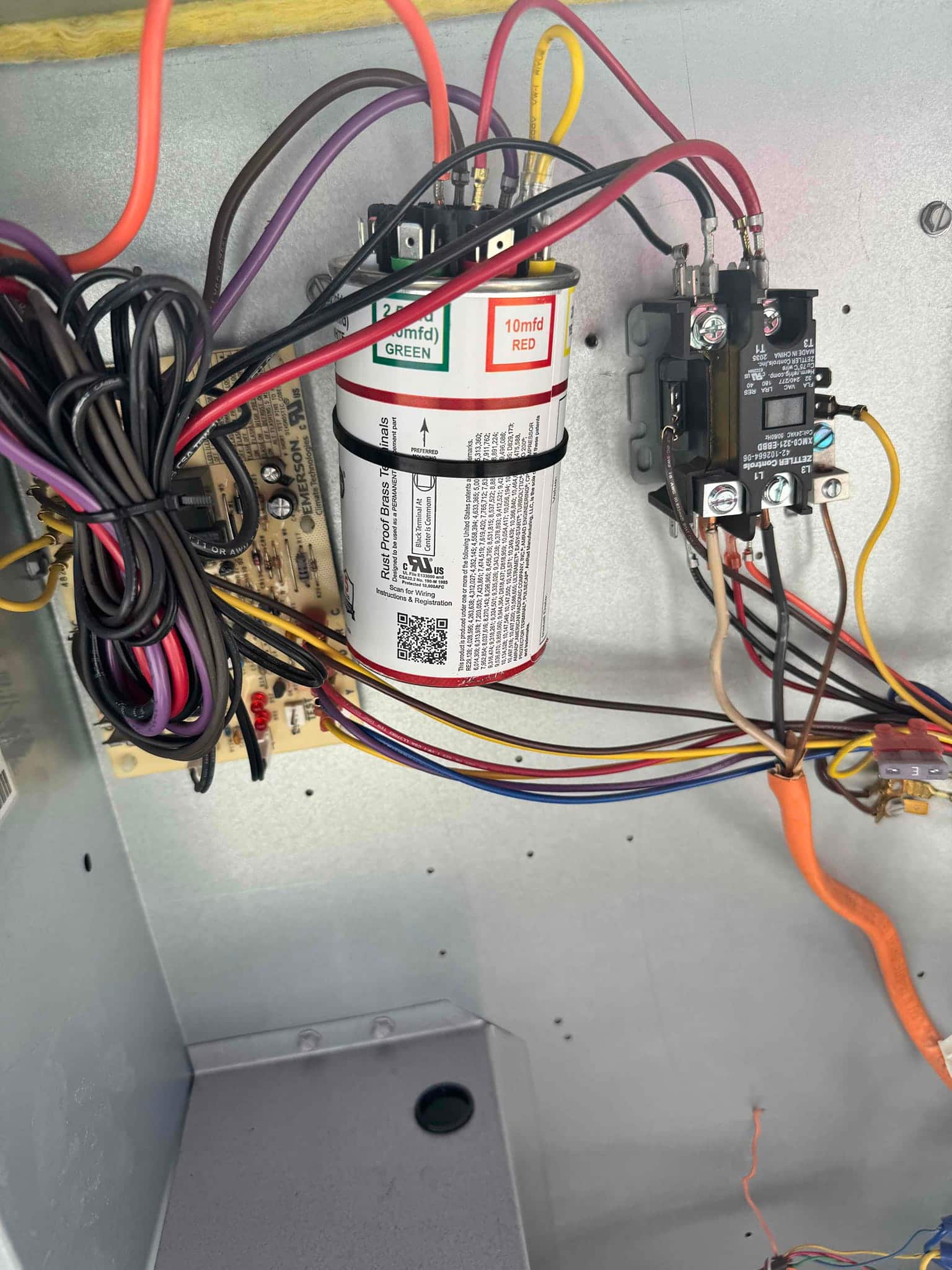 New dual-run capacitor rated 45/10 μF installed in condenser panel with neatly routed wiring and adjacent contactor.