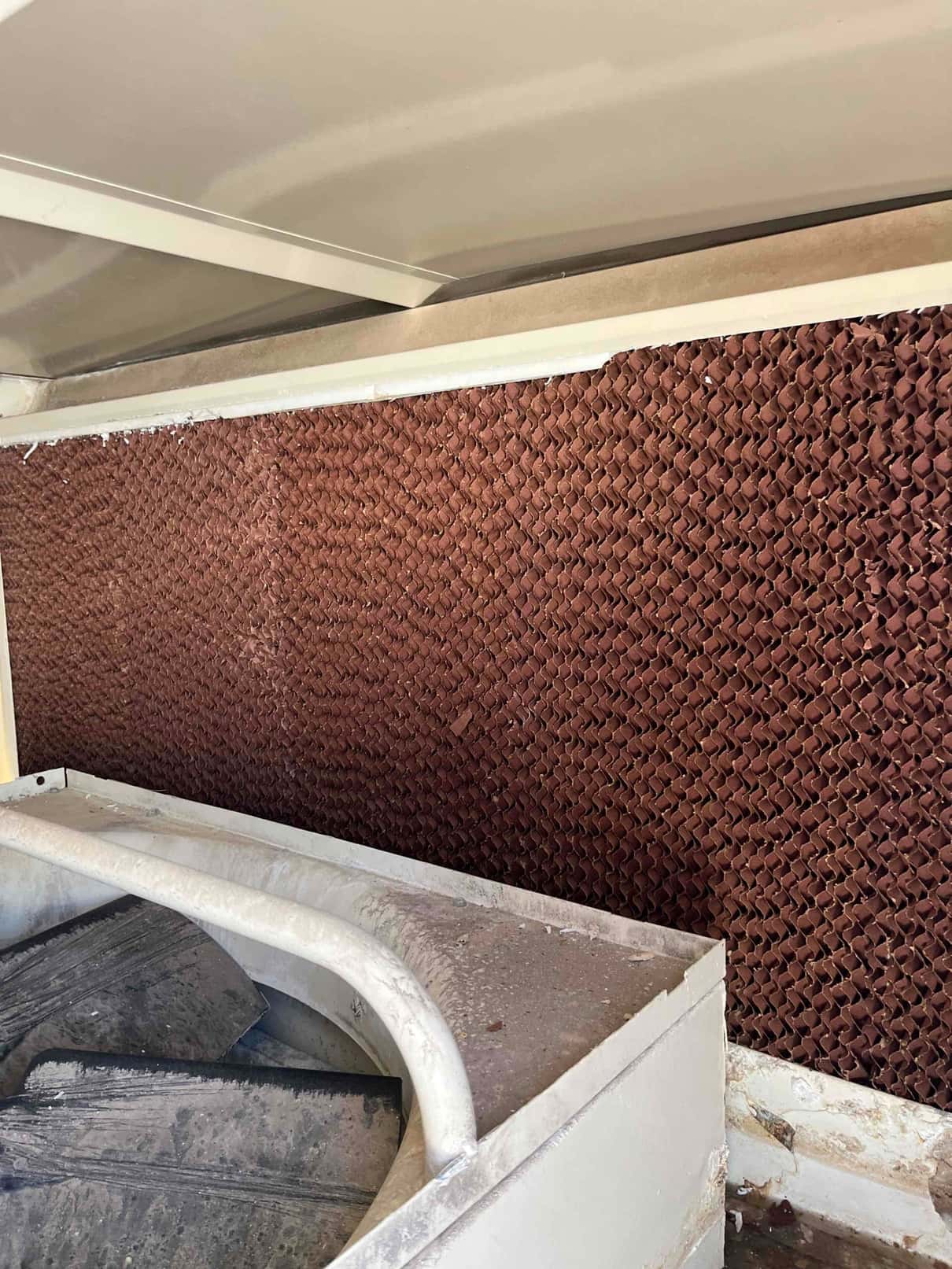 New evaporative cooler media pad installed inside the unit, showing clean, uniform cellulose structure and surrounding housing.