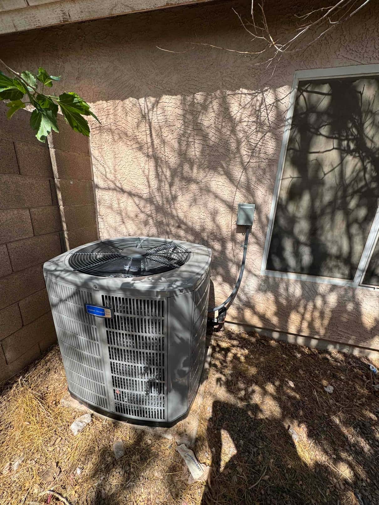 New outdoor condenser set on a level pad with disconnect box and insulated line set routed into the wall.