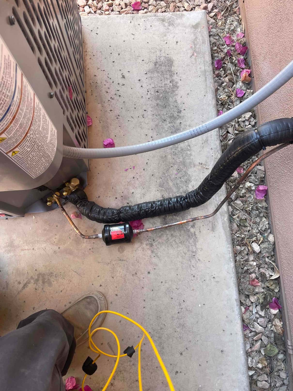 Outdoor condenser set on a pad with insulated refrigerant line set and inline filter-drier brazed into the liquid line.