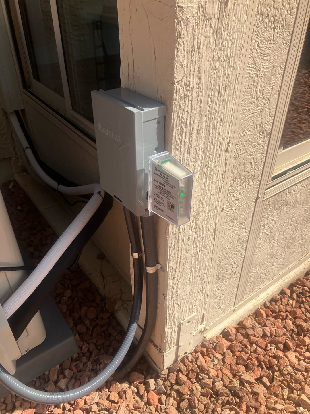 Outdoor disconnect with surge protector mounted and liquidtight conduits routed to the new mini‑split condenser location.
