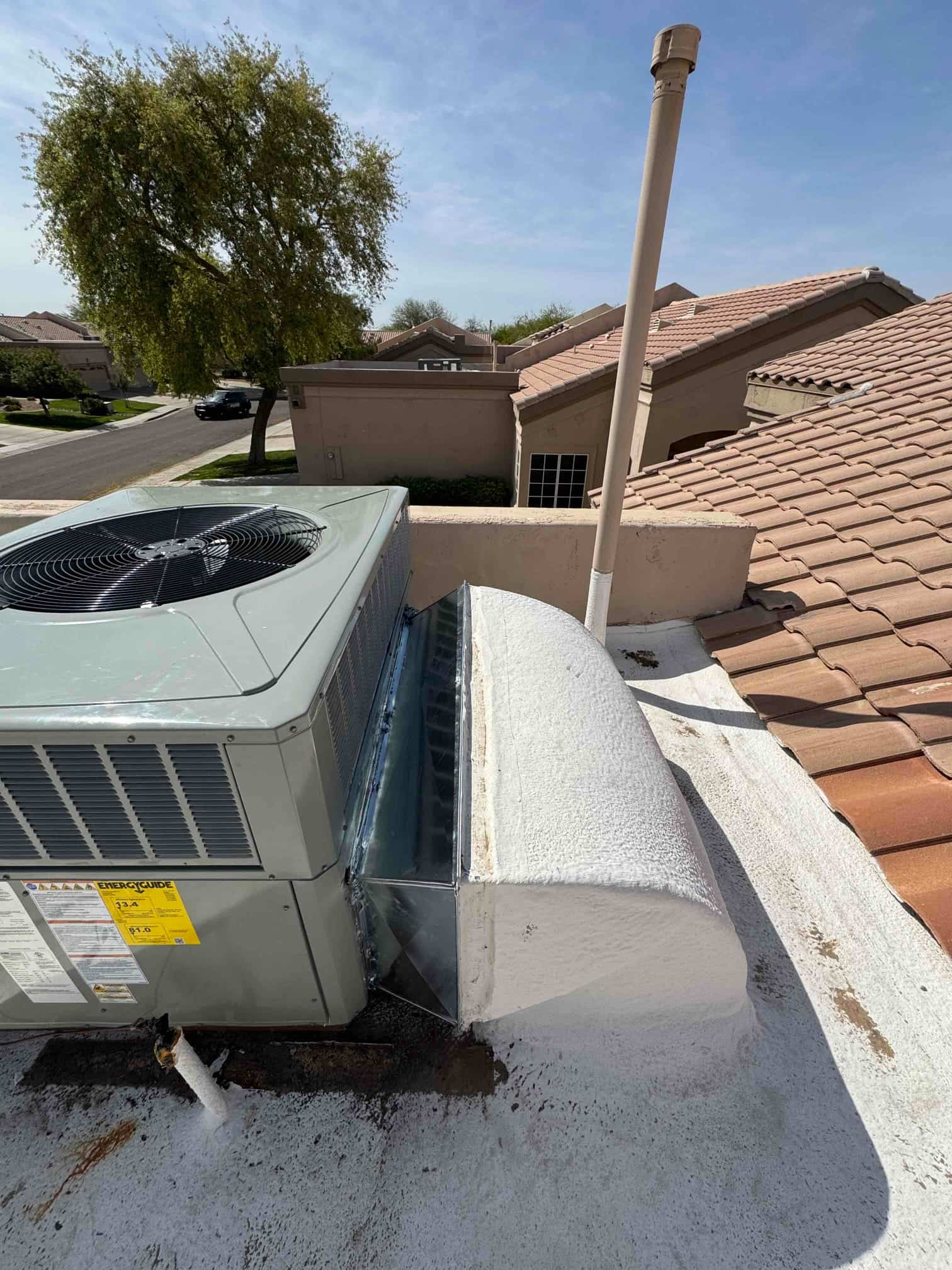 Rooftop 3.5‑ton package unit set on curb with new sealed sheet metal transition and insulated roof penetration.