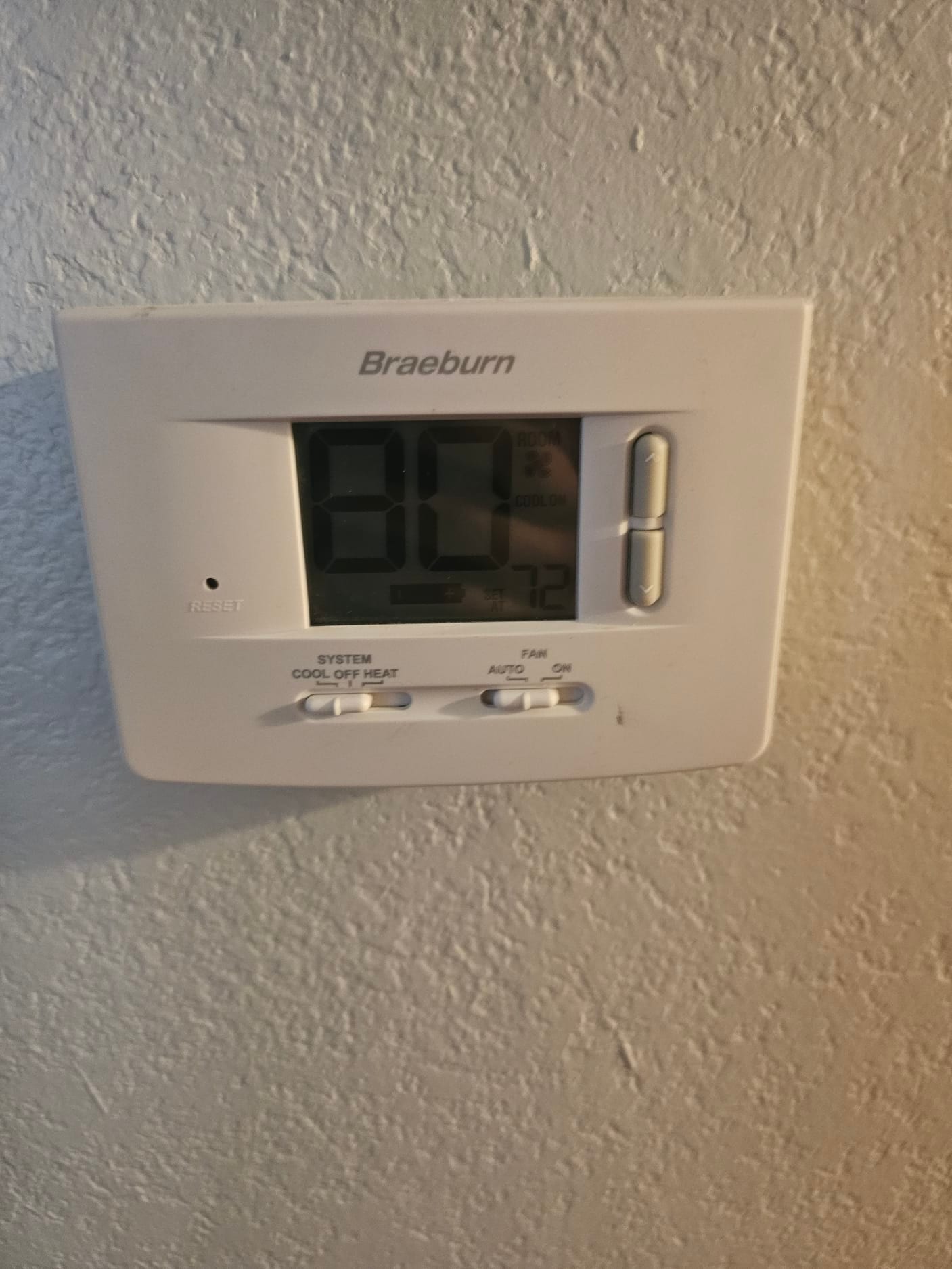 Wall-mounted digital thermostat displays room temperature 80 and set temperature 72, with the fan switch in Auto.